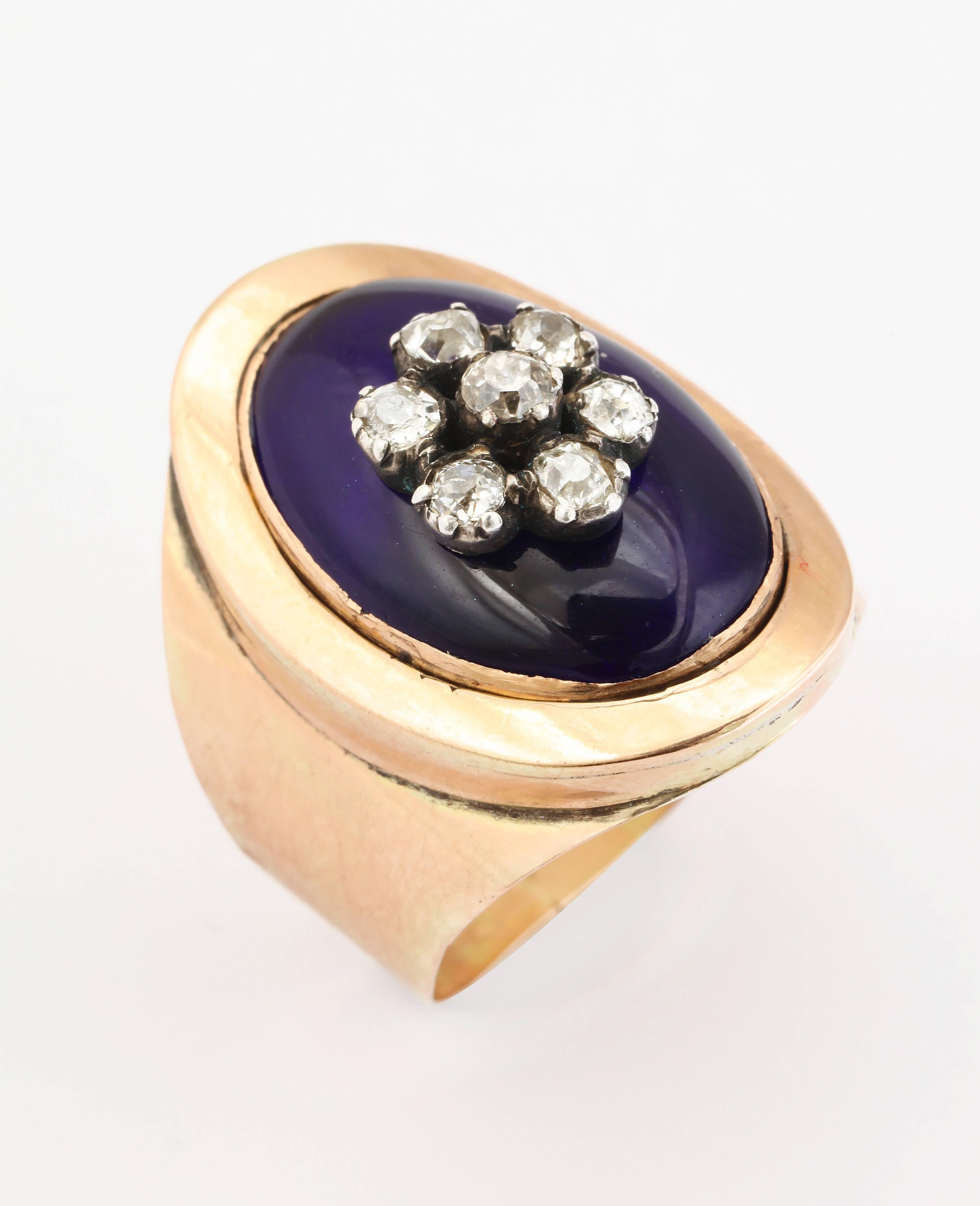 A stunning ring of 15 kt gold, lustrous medium blue enamel and a central diamond flower of antique diamonds makes an important appearance in its broad cigar band shank. This is high on my list of favorite style antique rings. It curves to the finger
