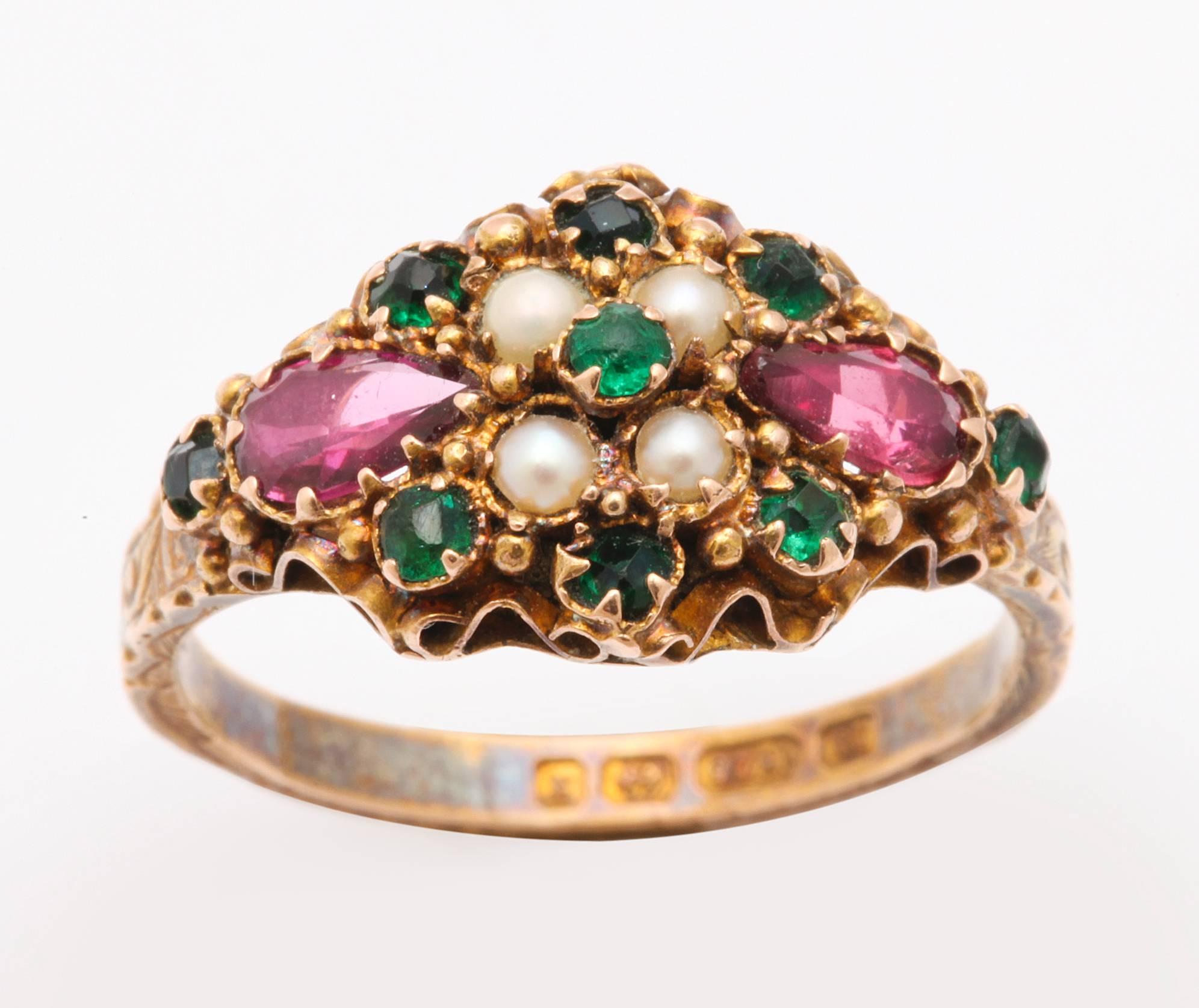 A delicious ruby, emerald and pearl ring with a marvelous 15 kt gold setting pulls no punches with beauty or symbolism. The colors of the gems , emerald, white and violet signify 