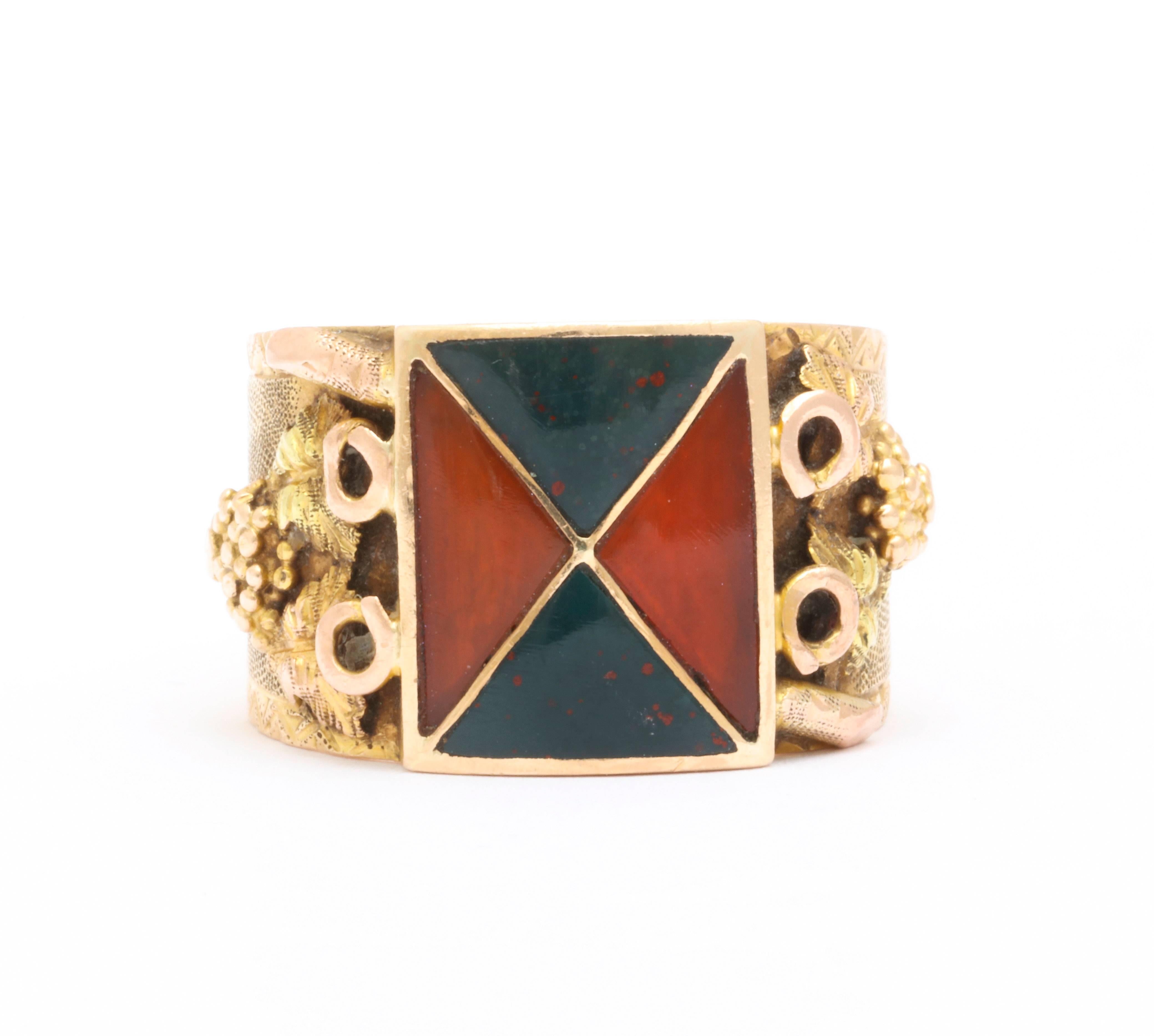 A Victorian agate ring in 18kt gold with superb texture and color holds geometrically set carnelian  and bloodstone in opposing triangles. Strong engraving on the shoulders was done in two ways. The background is hammered in the  tiniest pinpoint.