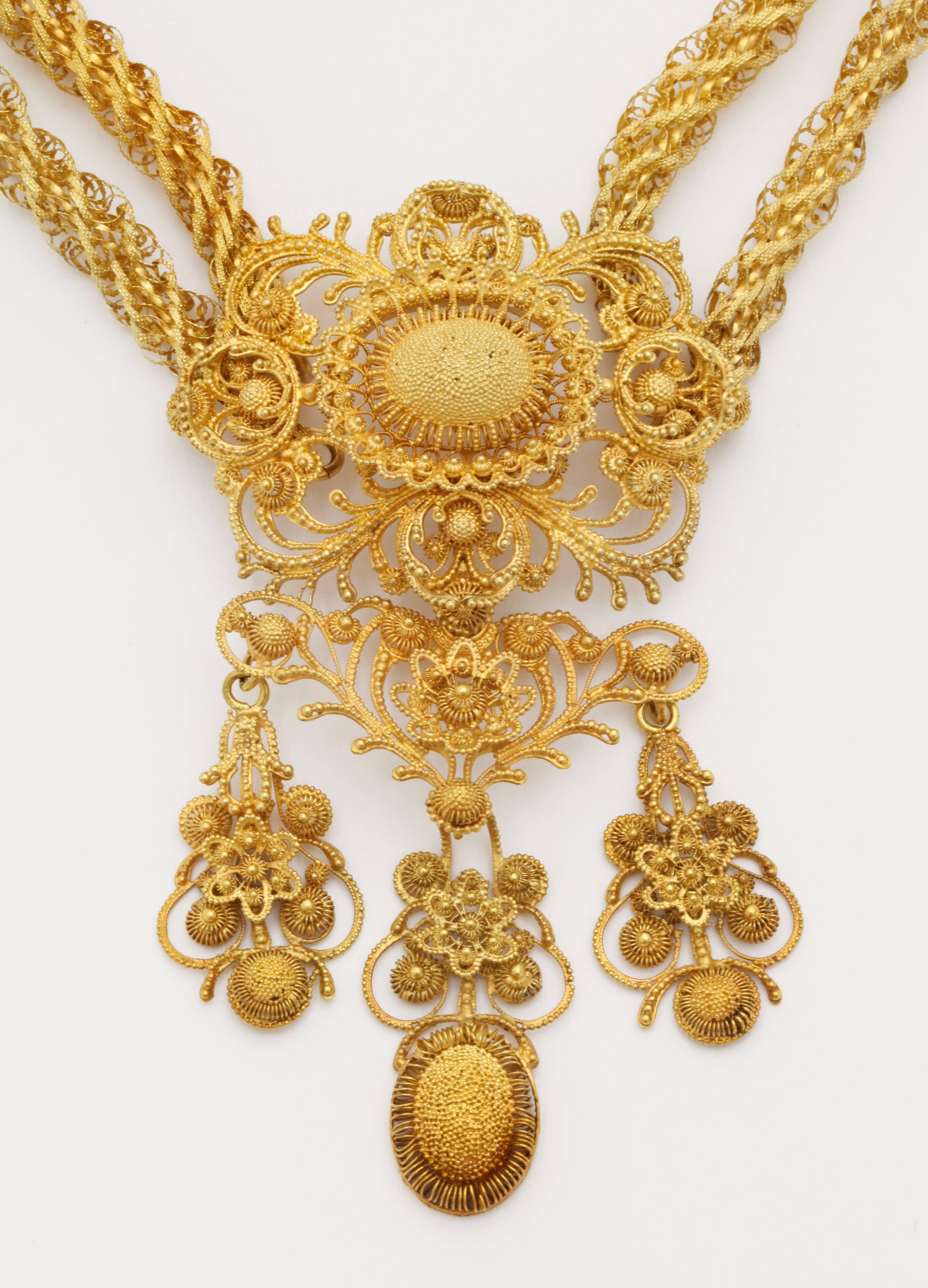  This masterpiece of gold work is a 15 kt gold cannetille necklace with earrings that will arrive with the glamour of an history movie. The jewels revel in the texture of solid and fine lacy spiral and scrolling designs that were created by hand.