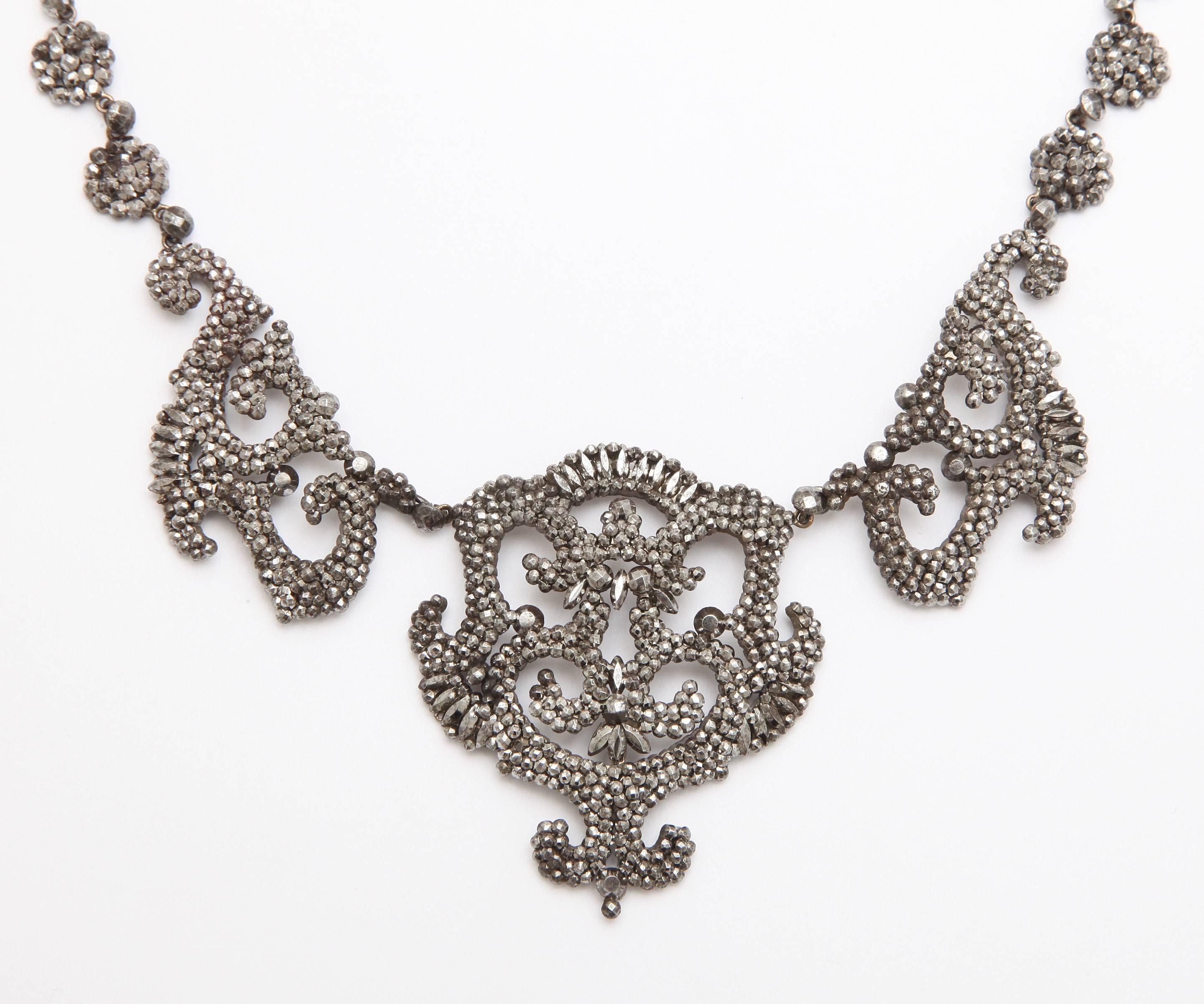 A crowning glory of design, this cut steel necklace shimmers like diamonds, in available light as it did originally in the early 1800's. Serves dressy occasions or denim shirts and blue jeans by bringing a unique sense of style with its varied cuts