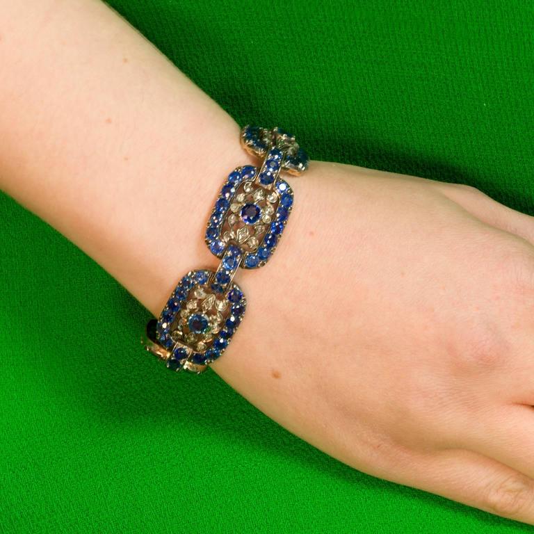 Sumptuous natural Ceylon Sapphires of bluest, vivid blue frame each diamond laced link while the center sapphire in each link sets a perfect balance.
The gold is 18 Kt. There are 115 natural sapphires weighing approx 22 Cts. The brilliant rose cut