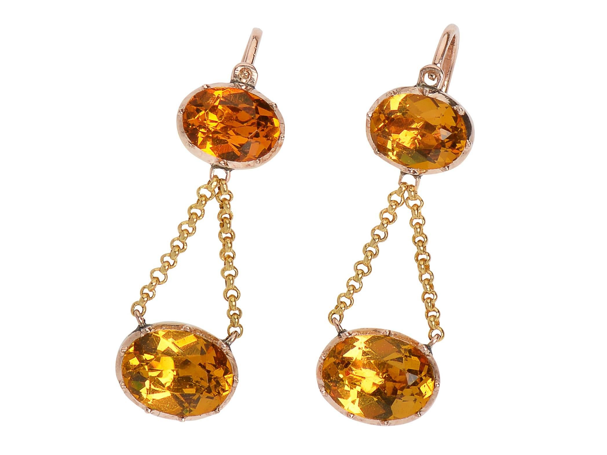 The glow of a flame sparkles across a room bringing  attention to these Georgian foiled citrine paste earrings c.1800-1820. Oval stones are set in closed 10 kt rose gold settings, hued to enhance the color of the pastes. More sheen than genuine