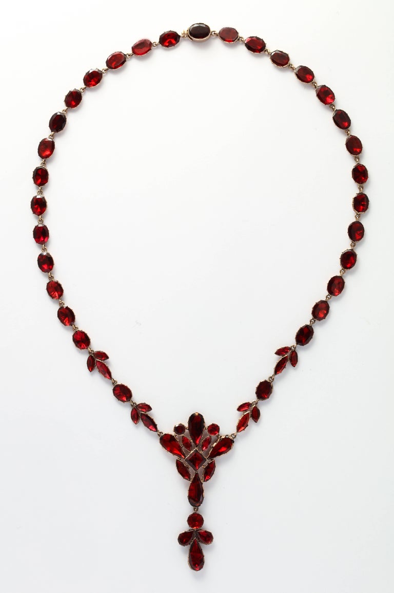 Blooming forms of red Georgian garnets lay smoothly on the neck and fall in a two and a half inch arrangement of flowers on the chest. Red is the color of passion. The beauty and ease of wear can be seen on the model. The reverse is the wonderful