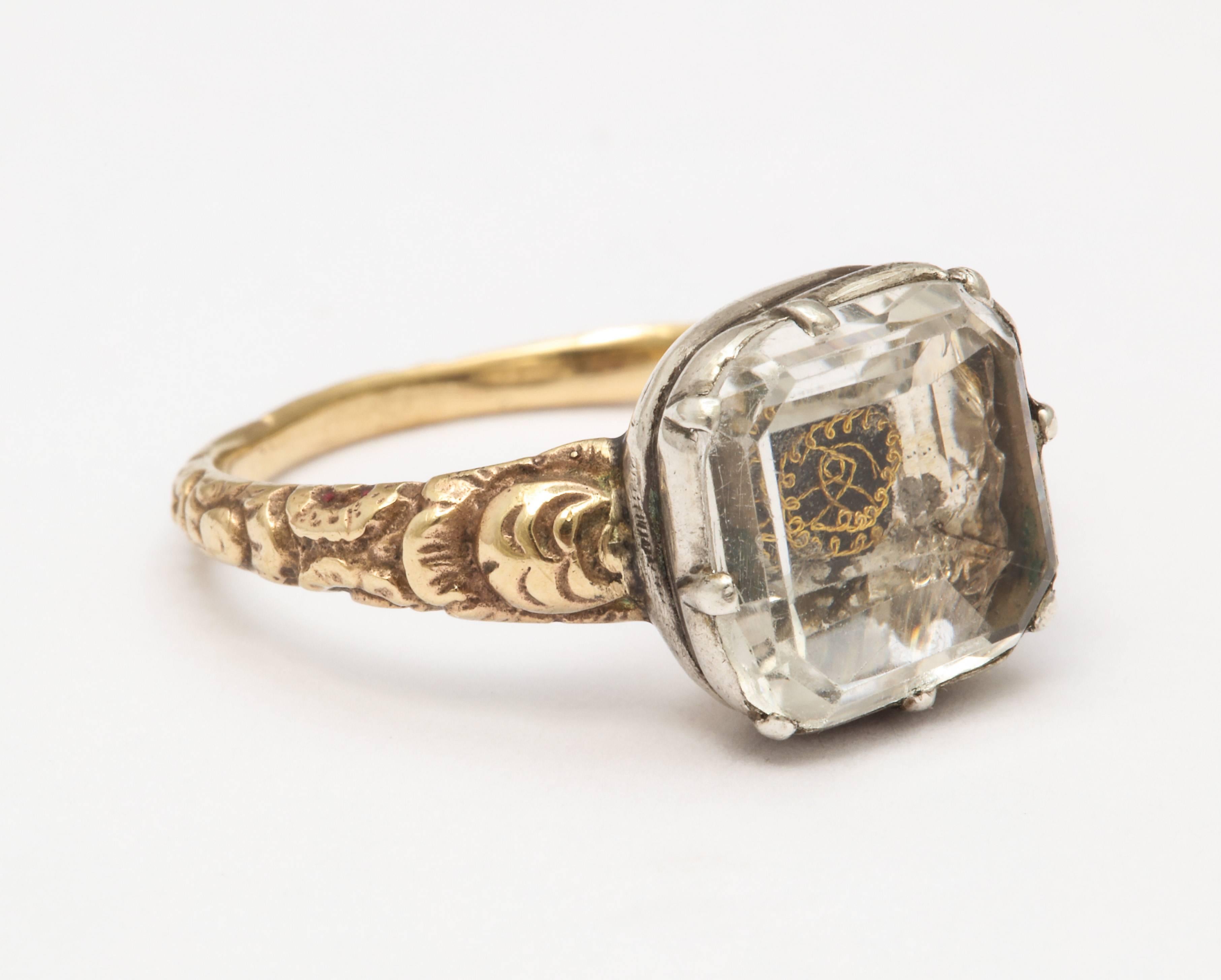 This gold iconic 4 ct. Stuart Crystal ring with its central gold thread spoke to us because of our attraction to  the clarity of the emerald cut rock crystal , its proportion. the lovely embossed engraving of the shank and the total elegance of the