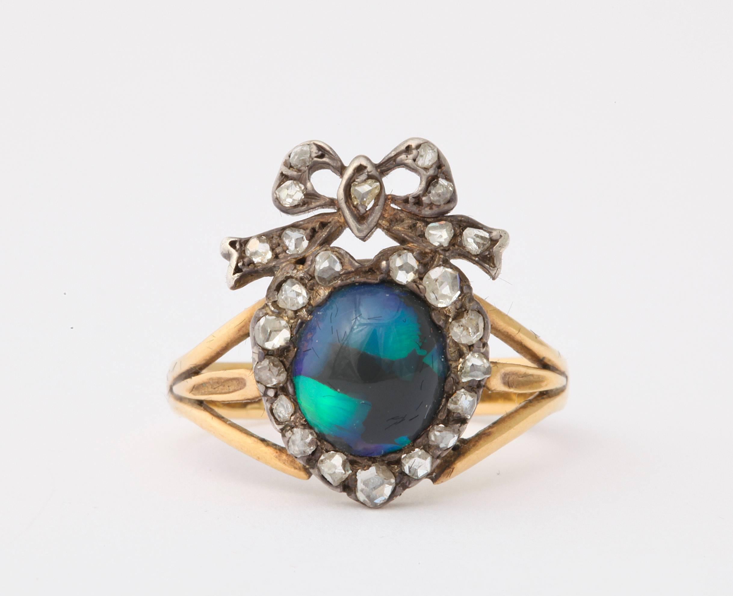 This beauty of a black opal and diamond ring touches the heart of the first to see it. The breath halts at the moment the color and iridescent glow strike the senses. Its quality sings in celebration of a relationship to each who view it . The stone