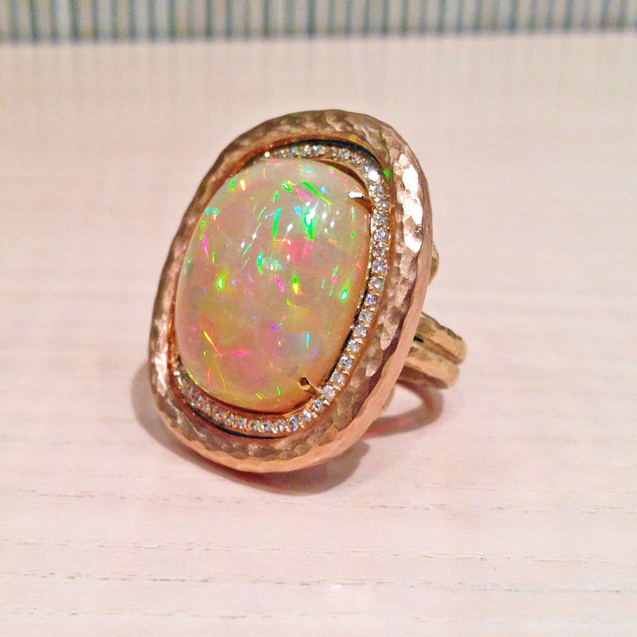 One-of-a-Kind Ring handcrafted by award-winning jewelry designer Pamela Froman showcasing an extraordinary 14.36 carat Ethiopian opal with confetti fire, surrounded by 0.27 carats of F/vs round brilliant-cut white diamonds and set in a hammered and