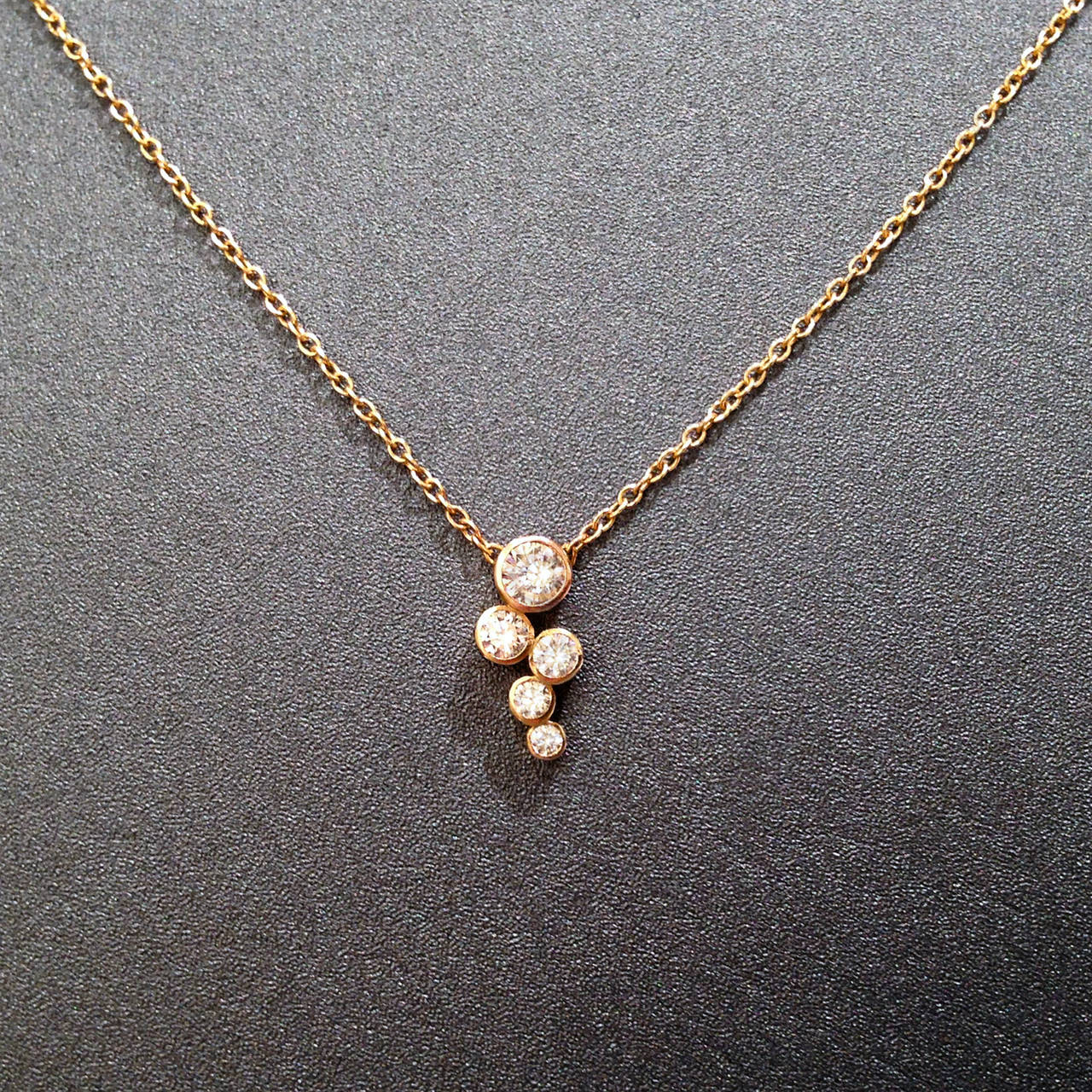 Handcrafted Bubbles Necklace on a 14k rose gold chain with the top round, brilliant-cut white diamond set in 14k rose gold and the lower four round brilliant-cut diamonds set in 14k yellow gold. 16.5