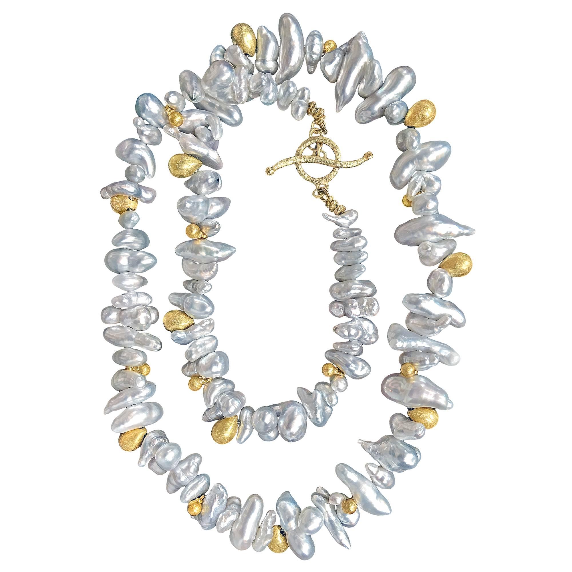 One of a Kind Necklace handcrafted by award-winning jewelry designer Barbara Heinrich featuring a spectacular strand of lustrous bluish silver keshi pearls accented with assorted solid 18k gold drop elements and a handmade wavy toggle clasp. Stamped