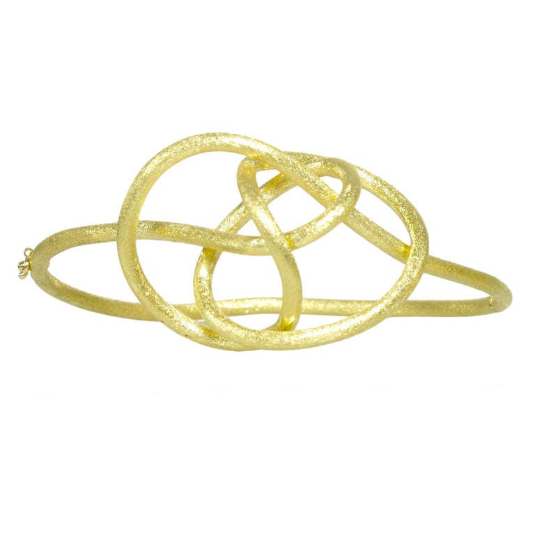 Hand-crafted Love Knot Bracelet in 18k yellow gold with a satin finish.
