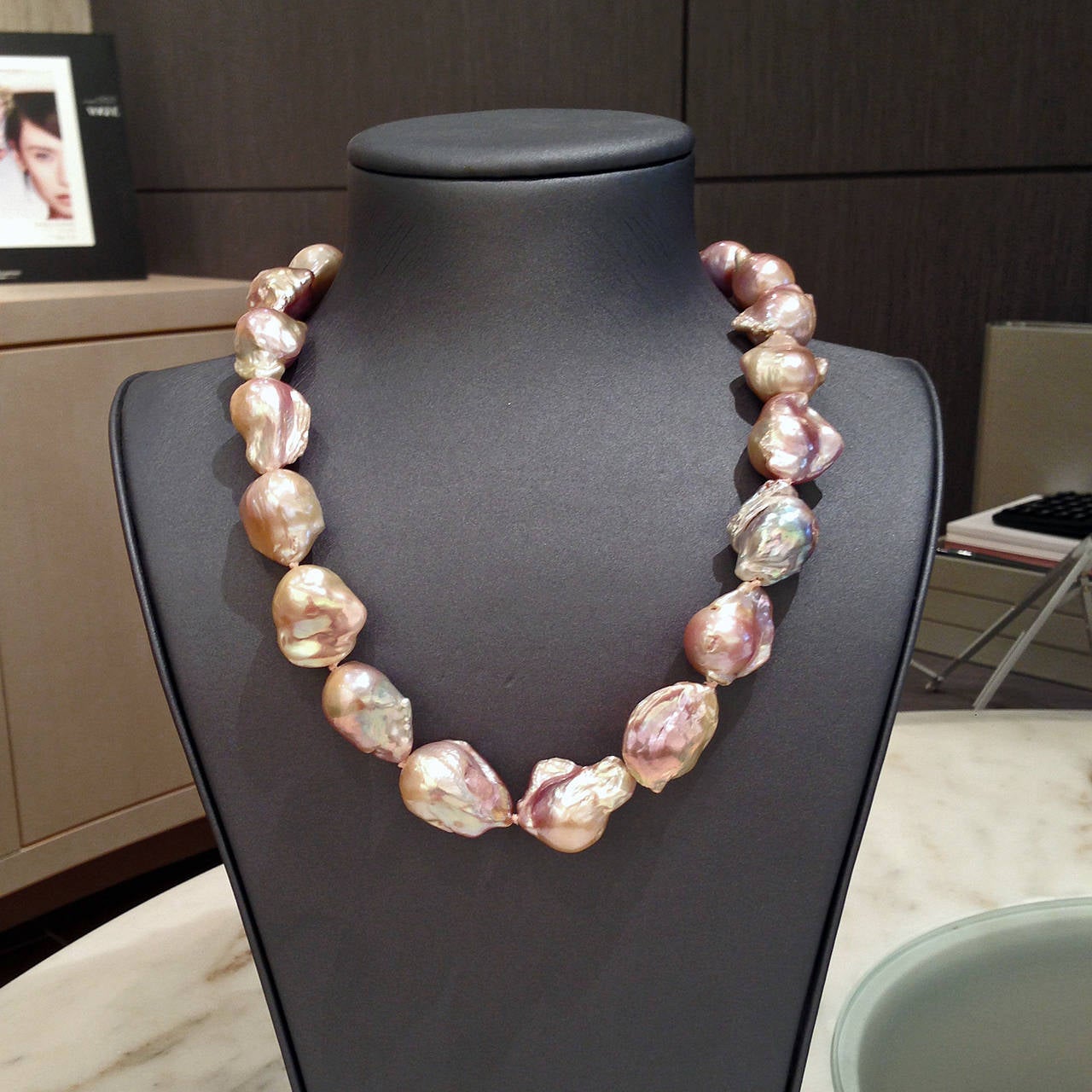 Necklace handcrafted and strung with an 18k yellow gold toggle clasp and 21 spectacular pink, purple, and blue baroque pearls averaging 18mm x 20mm in size. Nucleated freshwater pearls from China, the combination of their fantastic natural color,