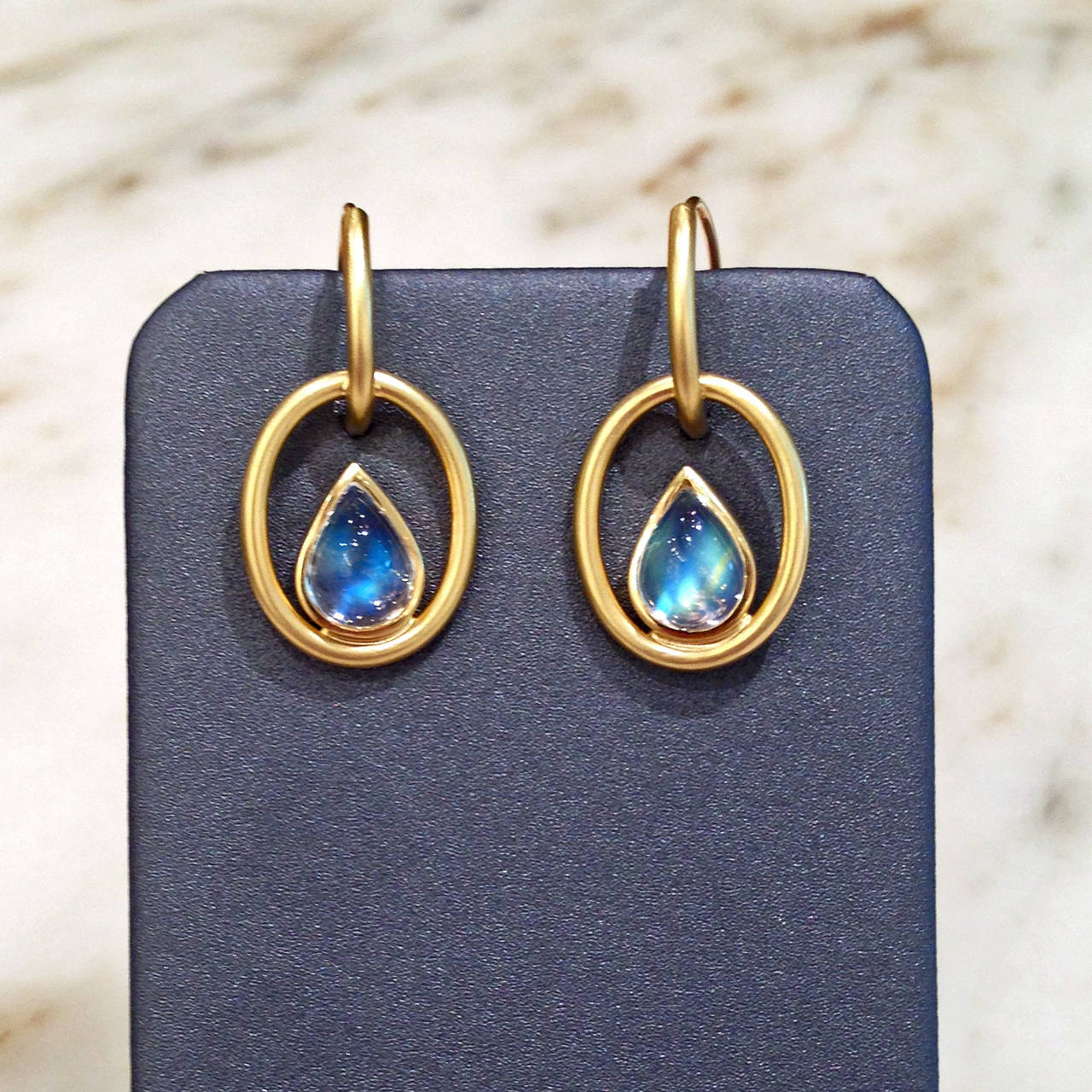 One-of-a-Kind Interlink Earrings handcrafted in 18.5k yellow gold with 3.50 carats of cabochon-cut pear-shaped blue moonstone and 18.5k yellow gold hook backs. 

About the Artist: Susan Sadler has studied design for most of her life, and