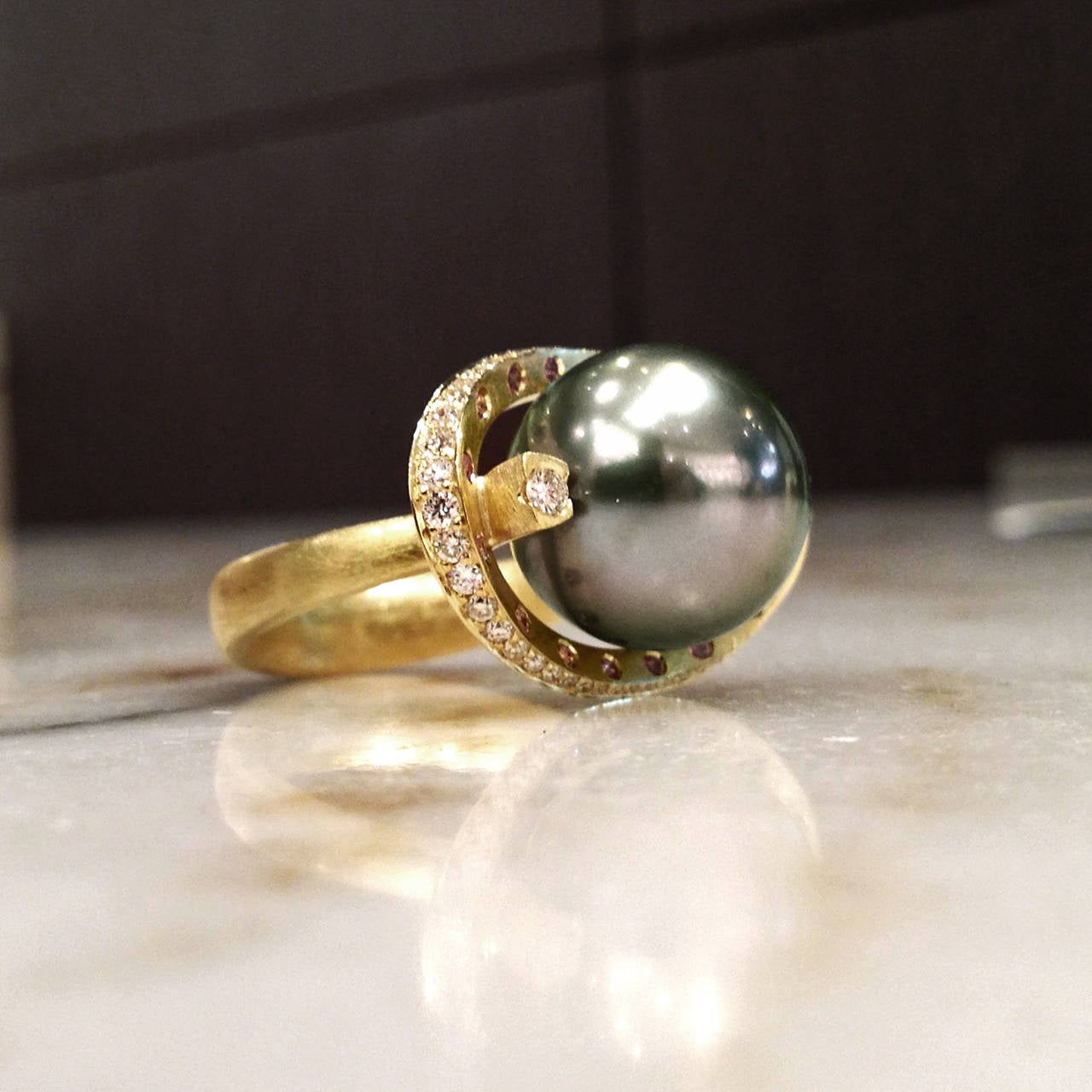 One-of-a-Kind Rolling Pearl Ring handcrafted in matte-finished 18k yellow gold with a stunning 13mm round Tahitian pearl accented by 0.40 total carats of round brilliant-cut vs1 white diamonds and 0.08 total carats of pale pink amethyst. Size 7.25