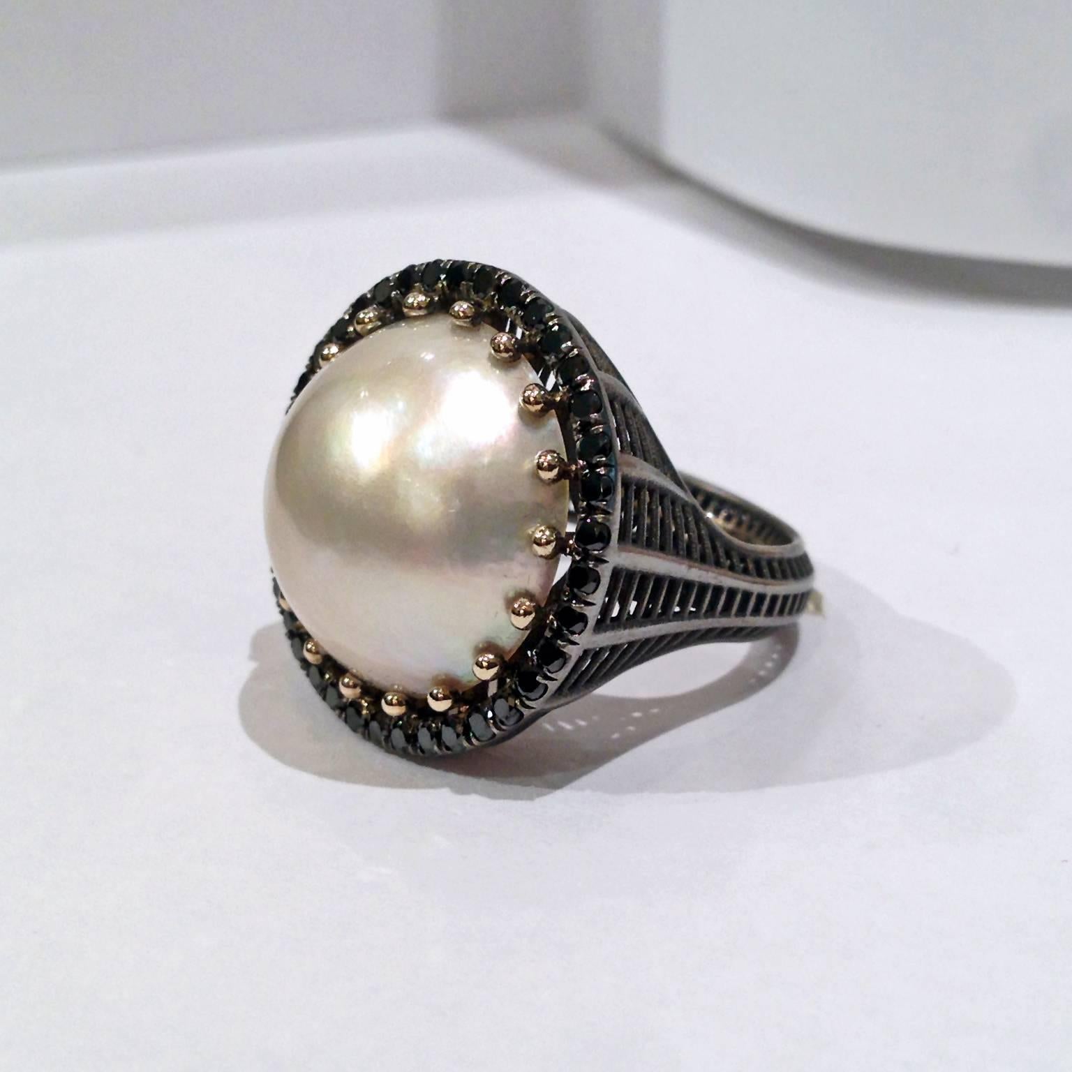 One-of-a-Kind Cabochon Cocktail Ring crafted in matte-finished 18k black gold with a lustrous, beautiful orient ten carat Mabe pearl set with shiny 18k yellow gold ball prongs and surrounded with 0.40 total carats of black diamonds. Size 7.0. 