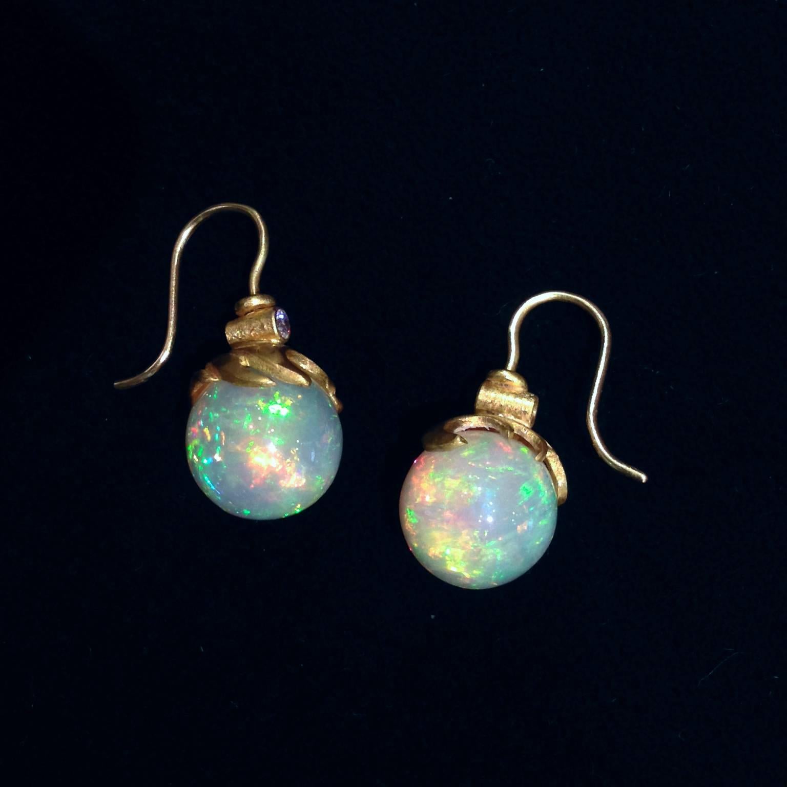 One-of-a-Kind Wave Earrings handcrafted by acclaimed jewelry artist Lilly Fitzgerald in matte finished 22k yellow gold. The earrings showcase two perfectly hand-carved white Ethiopian opal spheres with brilliant color-play featuring greens, blues,