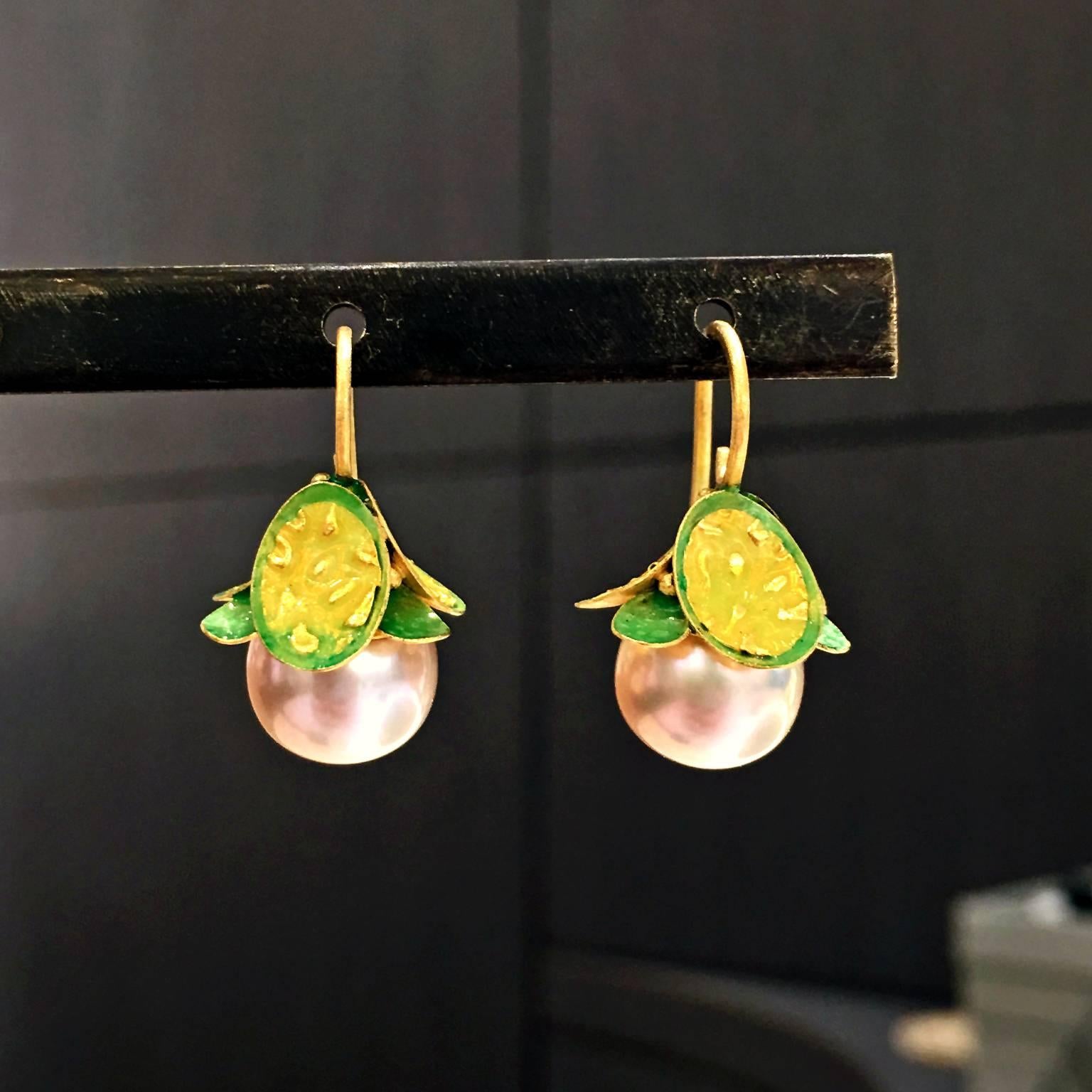Drop Earrings handcrafted in 21k yellow gold and 24k gold with soft pink freshwater pearls under green and yellow opalescent enamel leaves. 