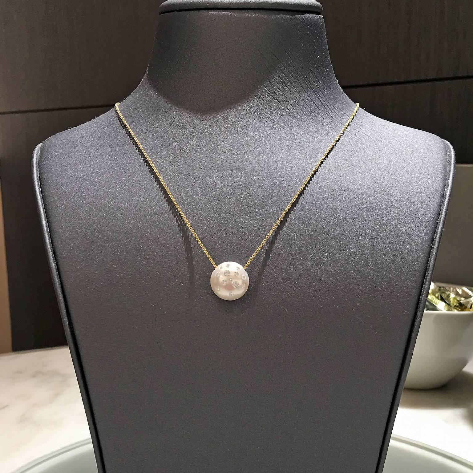 Freshwater Pearl Drop Necklace by renowned jewelry designer showcases a stunning, lustrous white freshwater pearl (12mm x 12mm x 10mm) with pink and violet tone. The pearl features 0.38 total carats of Russell's signature embedded round
