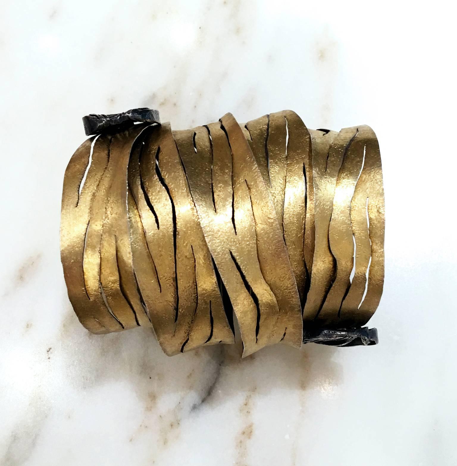 One of a Kind Spiral Wrap Bracelet handcrafted by jewelry designer and maker Reiko Ishiyama with four wrapped rows of intricately-finished, hand-cut 22k yellow gold and oxidized sterling silver sheets. The magnificent statement cuff is finished with