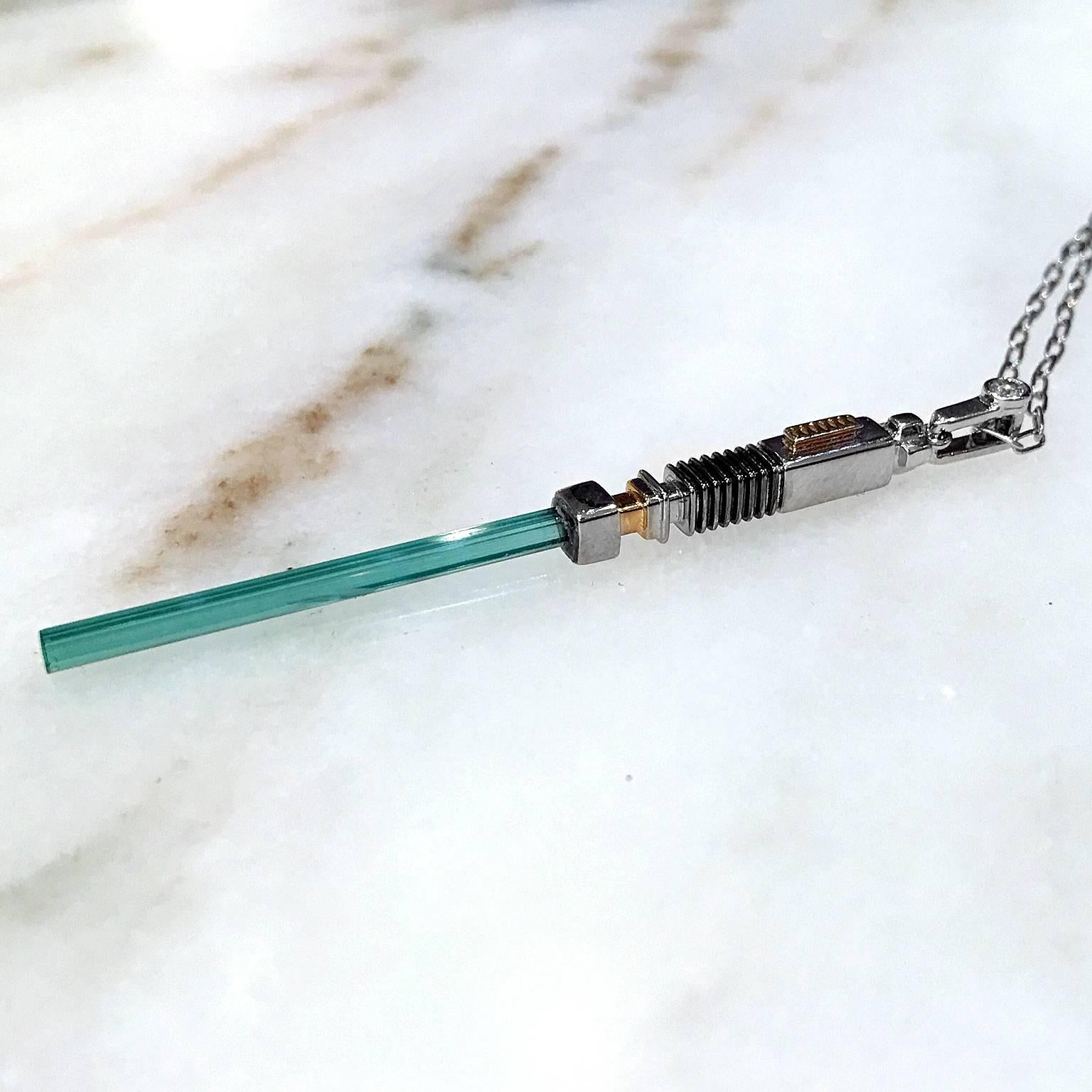 One of a Kind Star Wars inspired LightSaber Necklace handmade in 18k yellow gold and 18k white gold showcasing a stunning, rare bluish green tourmaline crystal and accented with a white diamond bail on an 18
