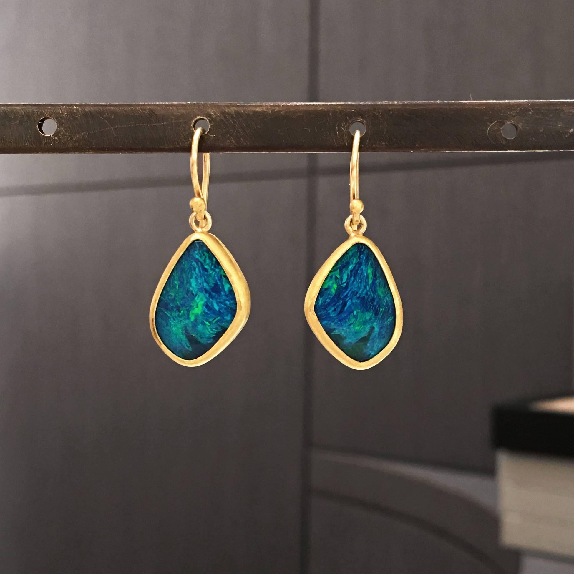 One of a Kind Drop Earrings handcrafted by jewelry artist Petra Class featuring two violet blue opal doublets with lively neon green flash, bezel-set in matte-finished 22k yellow gold on 18k yellow gold ear wires. 

Stamped and Hallmarked - 22 /