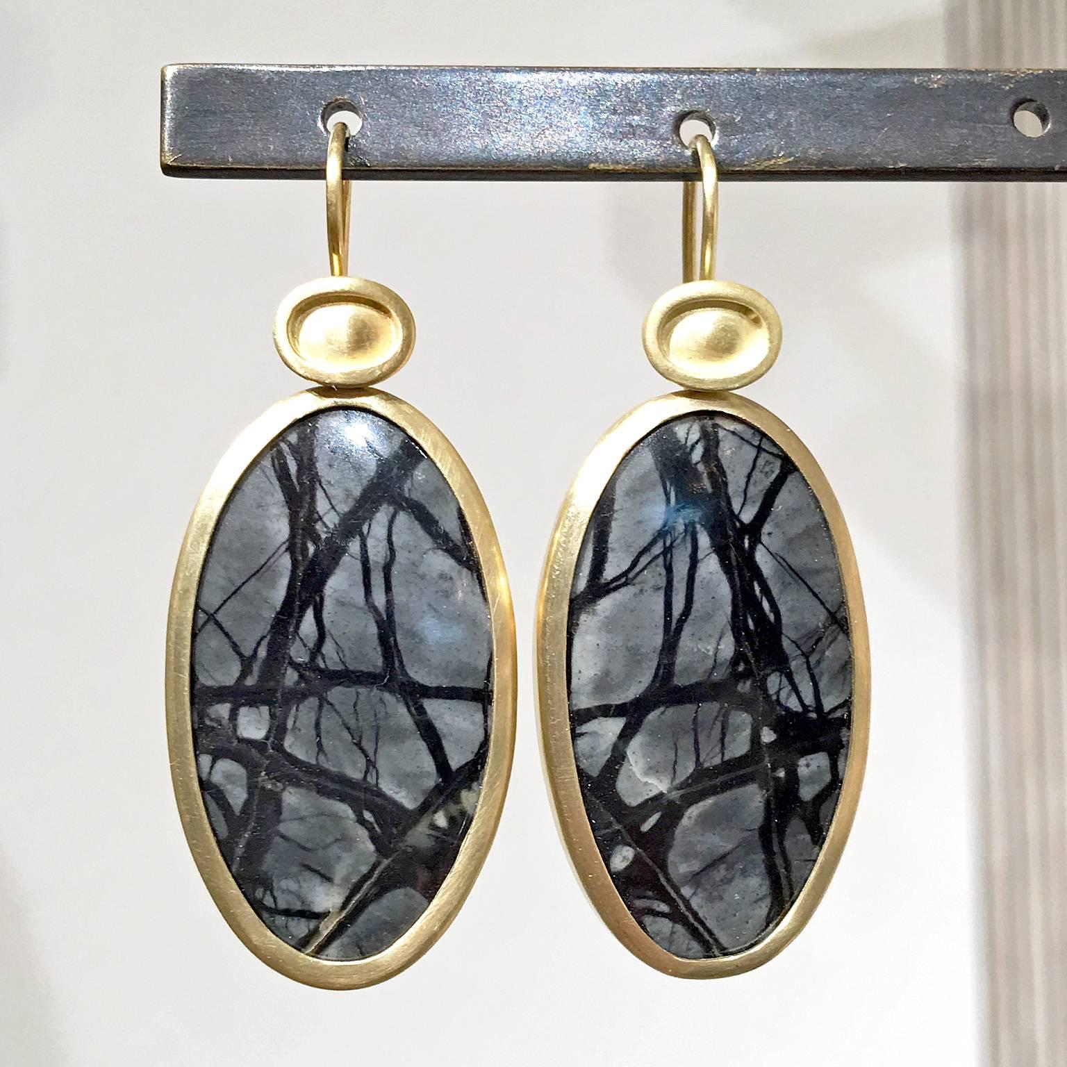 One of a Kind Drop Earrings handcrafted by jewelry artist Monica Marcella in matte finished 18k yellow gold featuring a matched pair of natural steel-toned gray and black jasper cabochons bezel-set below Monica's signature shield elements and