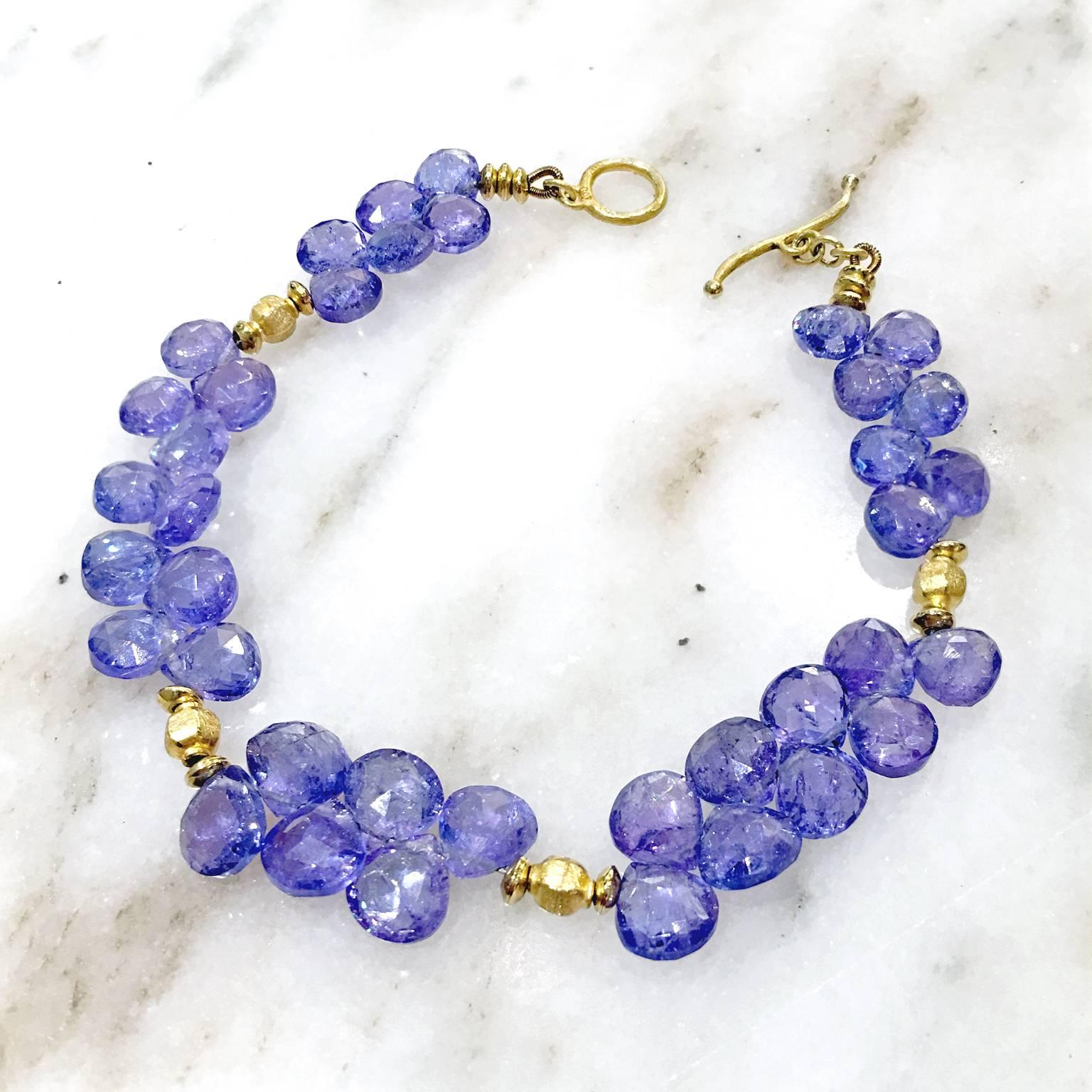 Briolette Bracelet handcrafted in matte-finished 18k yellow gold featuring 38 shimmering faceted tanzanite briolettes and a curved toggle clasp. Stamped Au / 750 with Barbara's signature leaf hallmark. 