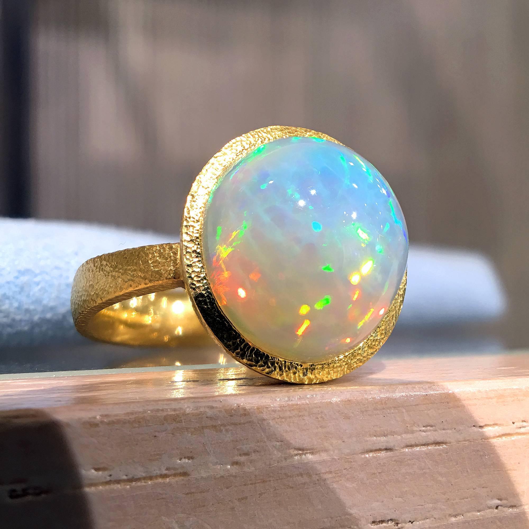One of a Kind Ring handcrafted by acclaimed jewelry designer Devta Doolan featuring a breathtaking, completely natural translucent Ethiopian white opal(12.5mm x 11.5mm) with strong primary flashes of electrifying green and orange complemented by