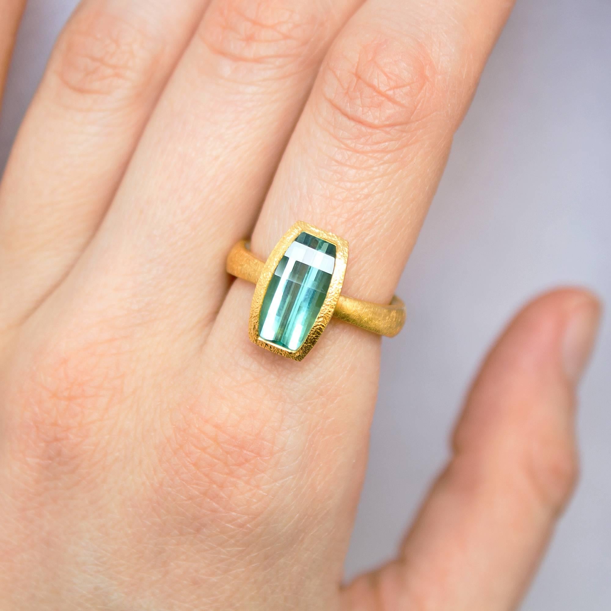 One of a Kind Ring handcrafted by jewelry artist Devta Doolan in 22k yellow gold featuring a spectacular blue green tourmaline set vertically to accentuate the geometric optical effects within the  custom-cut gemstone. Size 6.25 (can be sized).