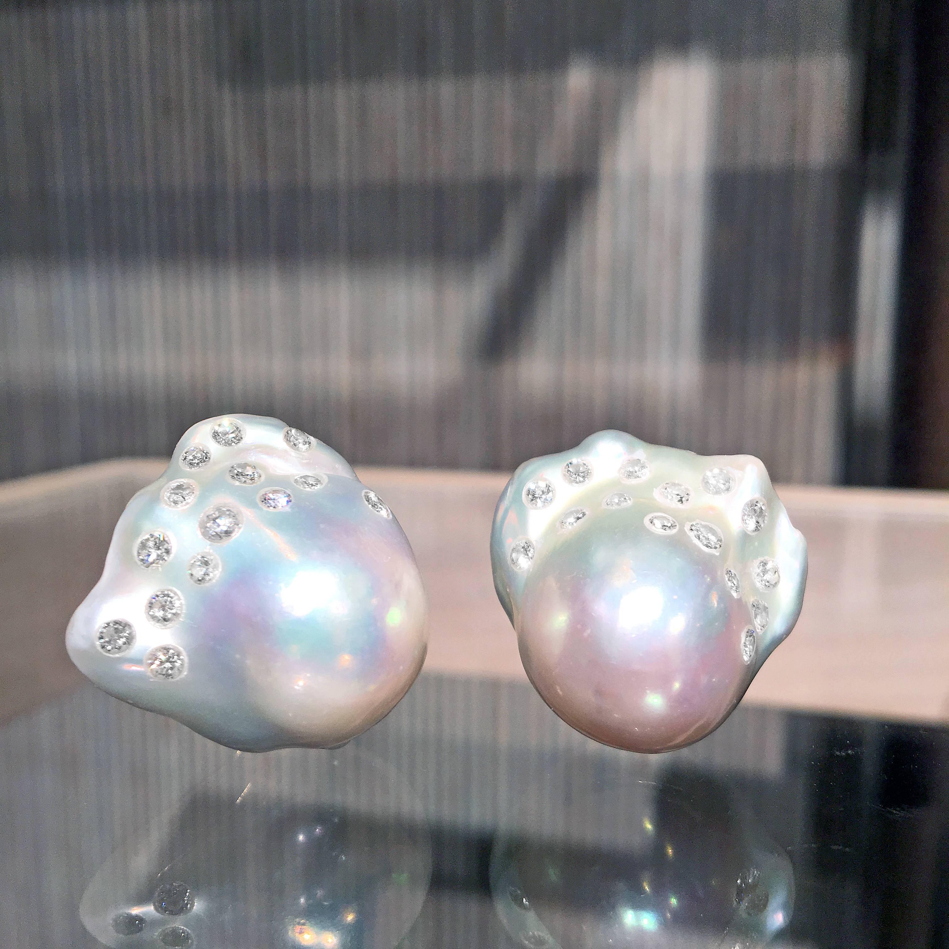 A matched pair of wonderfully iridescent South Sea Baroque Pearls (~ 23mm x 24.5mm) showcasing 1.02 total carats of round brilliant-cut white diamonds masterfully set by jewelry artist Russell Trusso and attached to 18k yellow gold omega backs