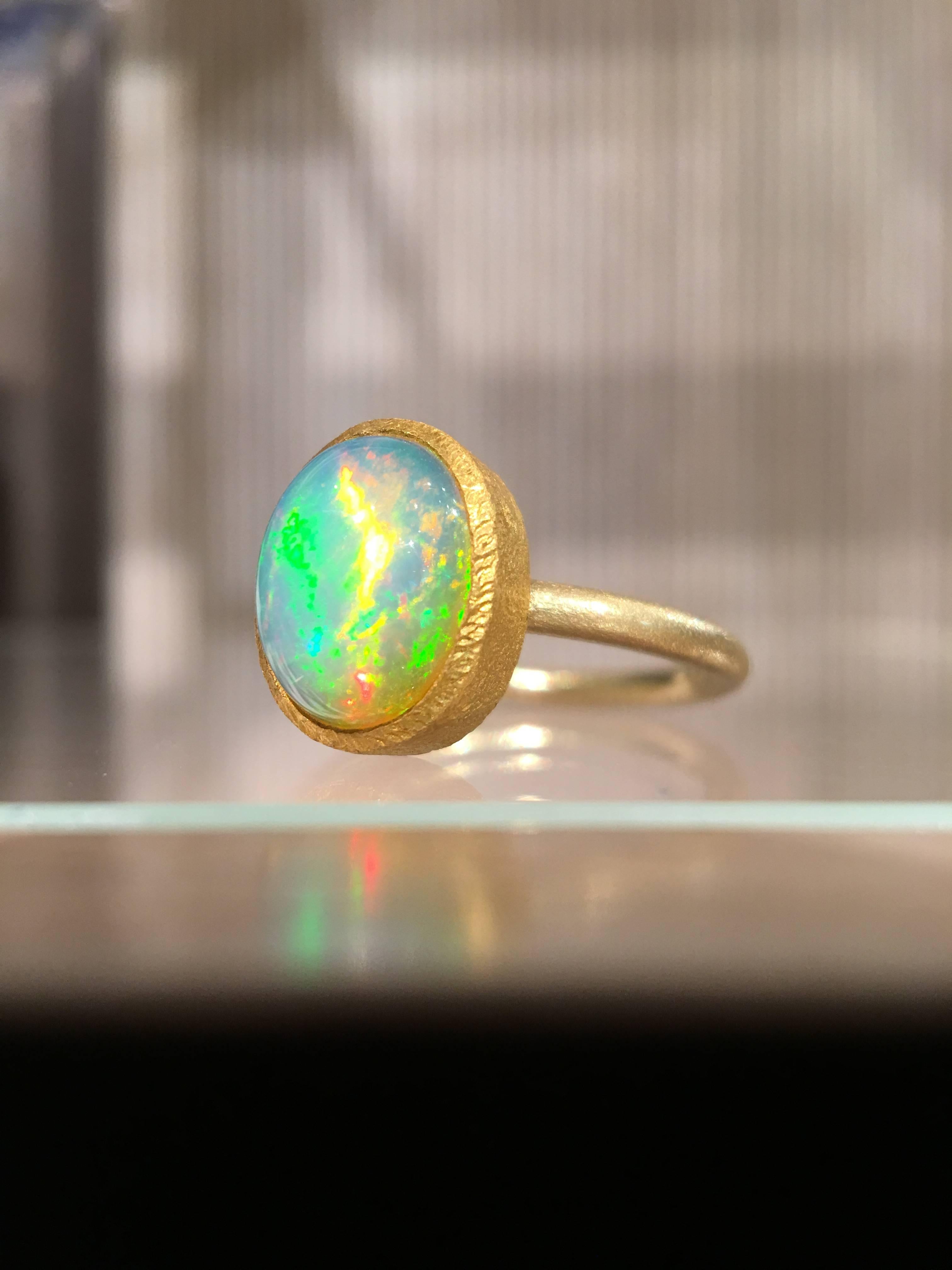 One of a Kind Ring handcrafted by acclaimed jewelry designer Devta Doolan featuring a breathtaking, completely natural translucent Ethiopian white opal (10mm x 7.5mm) with strong primary flashes of electrifying green, orange and pink complemented