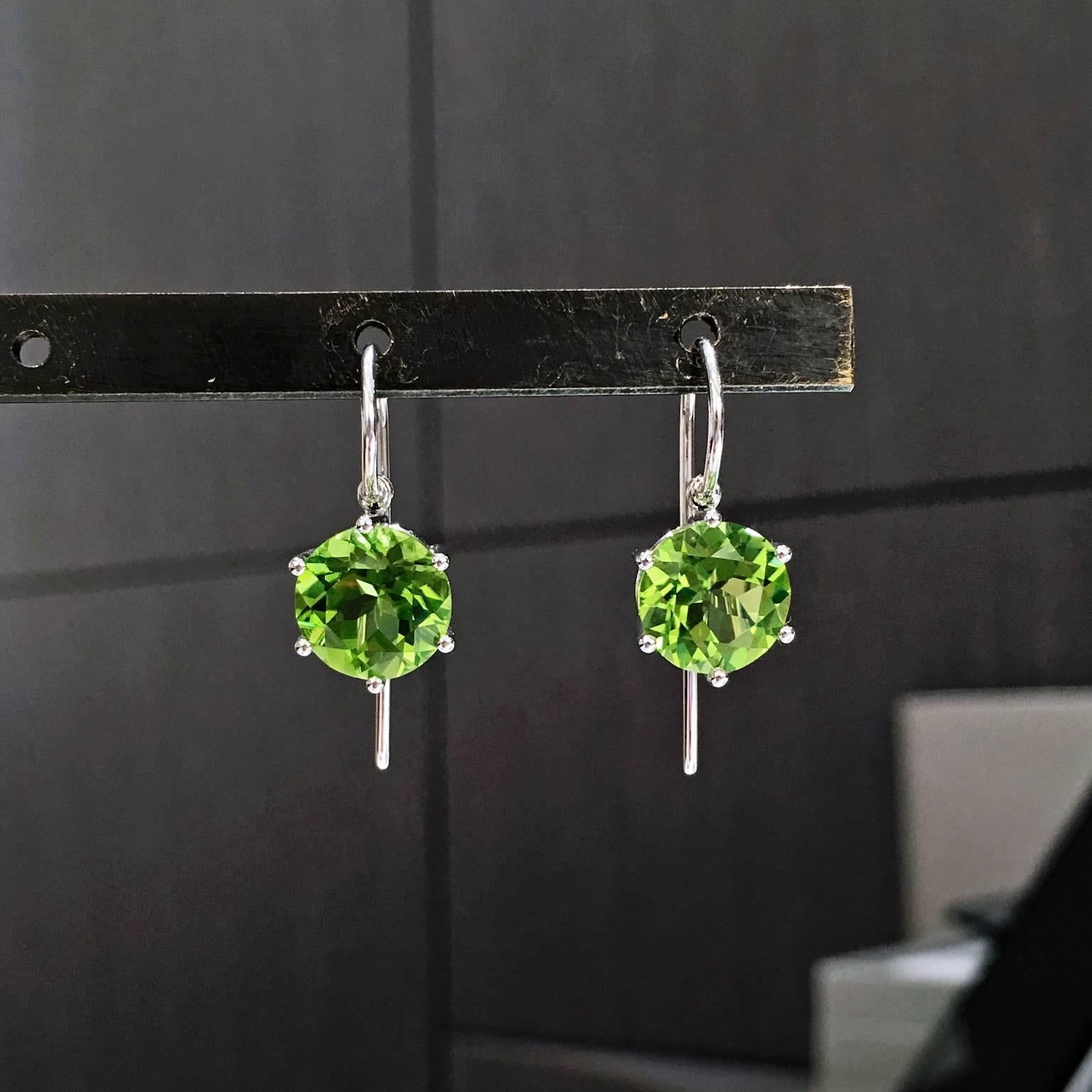 Princess Earrings, handcrafted by acclaimed jewelry artist and master metalsmith Erich Zimmermann, in 18k white gold with a gorgeous, fiery matched pair of 9mm slightly yellowish green peridot totaling 6.80 carats set with six ball prongs in an open