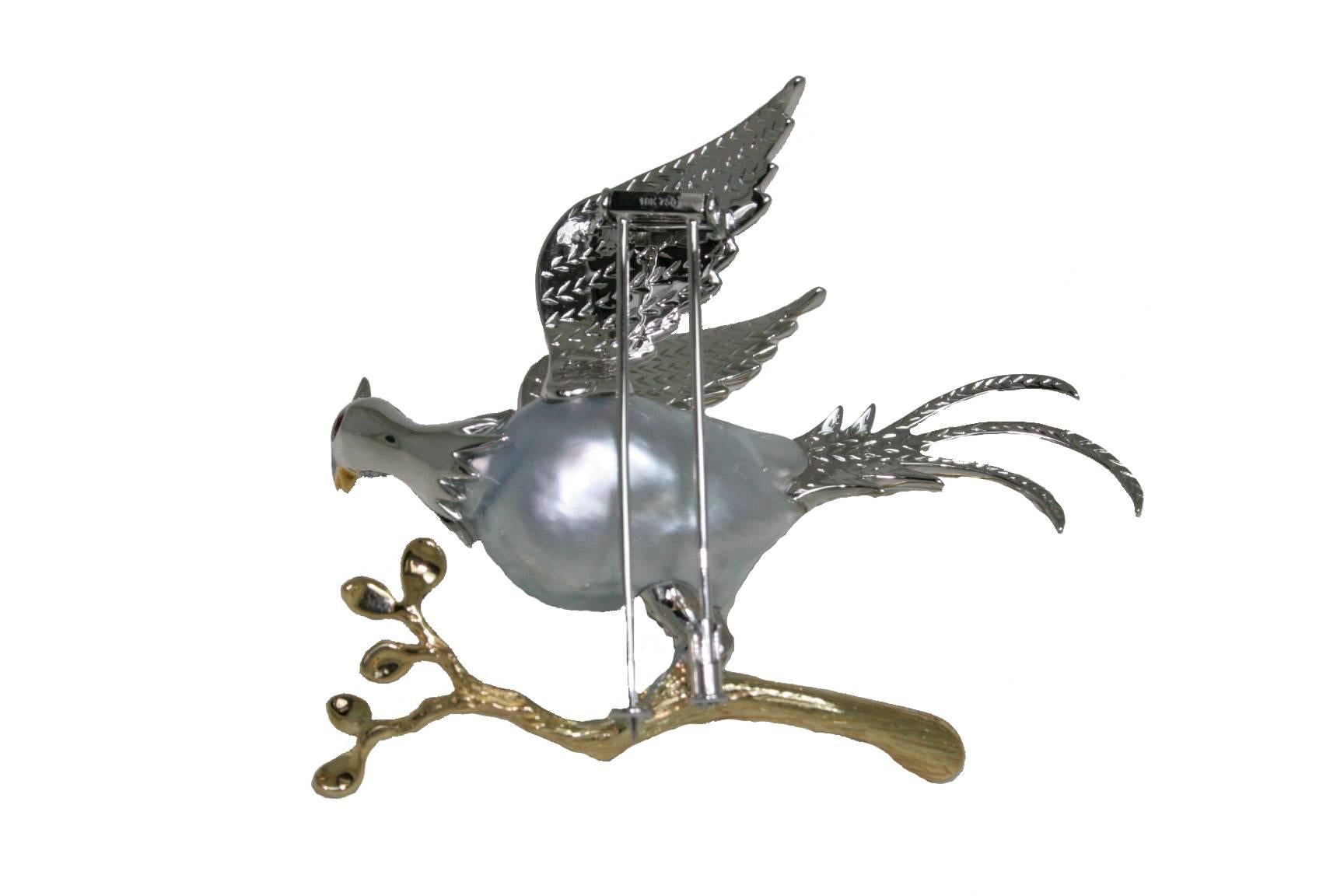 This bird perched on a branch brooch consists of a 16x17mm Natural Color Baroque Cultured White South Sea pearl, White Diamonds, Yellow Diamonds, Rubies, and Tsavorite. The brooch is 18 white and yellow gold.

Approximate Carat Weights:
White