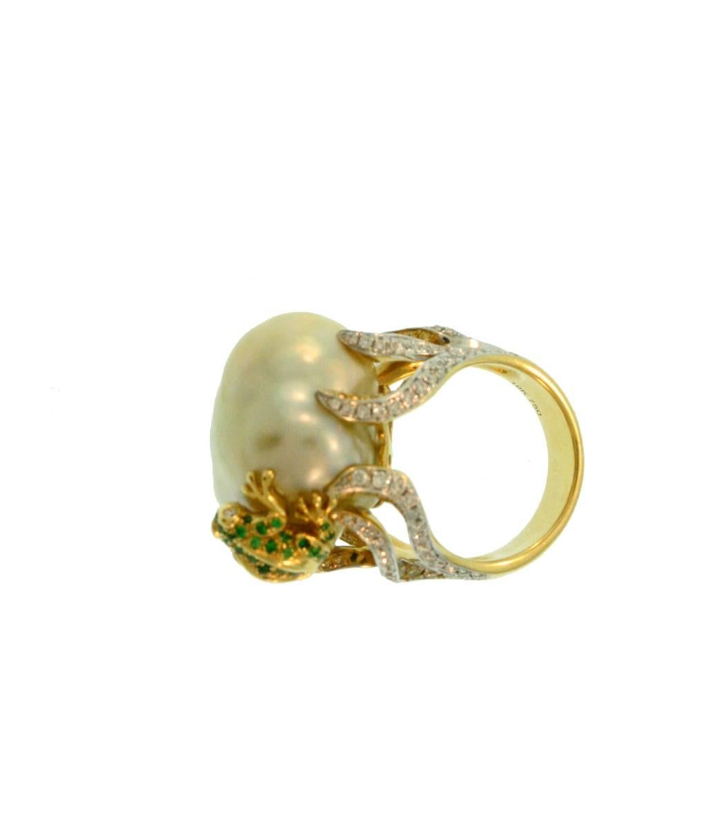 This fun one of a kind cocktail ring adds a bit of flair to any outfit! The frog, made of 18k yellow gold and Green Tsavorite, is climbing on a 17x18mm Natural Color Golden South Sea Cultured Pearl. The ring setting is 18k yellow gold consisting of