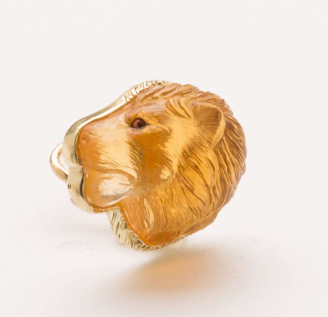 These realistically carved side facing citrine lion heads with painted eyes are set in polished 18karat gold surround with feathered mane detailing.  Created by Master Idar-Oberstein carver.
Adjustable lever gold backs for pierced or non-pierced