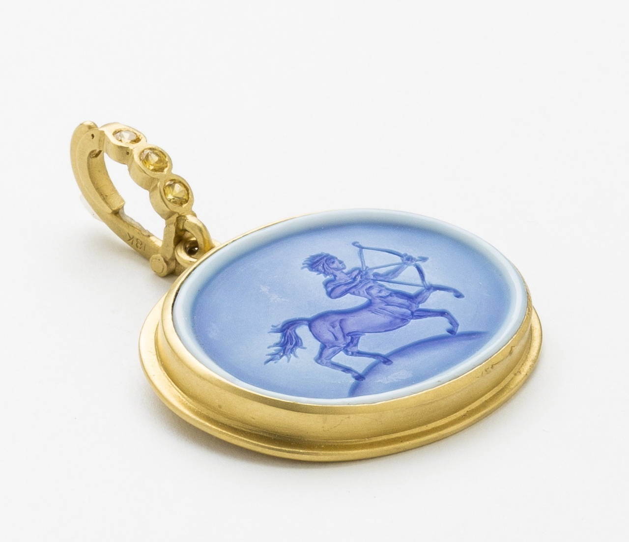 Hand engraved beautifully detailed depiction of Sagittarius (The Archer, whose arrow is pointing across the sky). The astrological sign of the wanderer and the Constellation Sagittarius. Carved in layered sky blue agate and set in an 18 karat