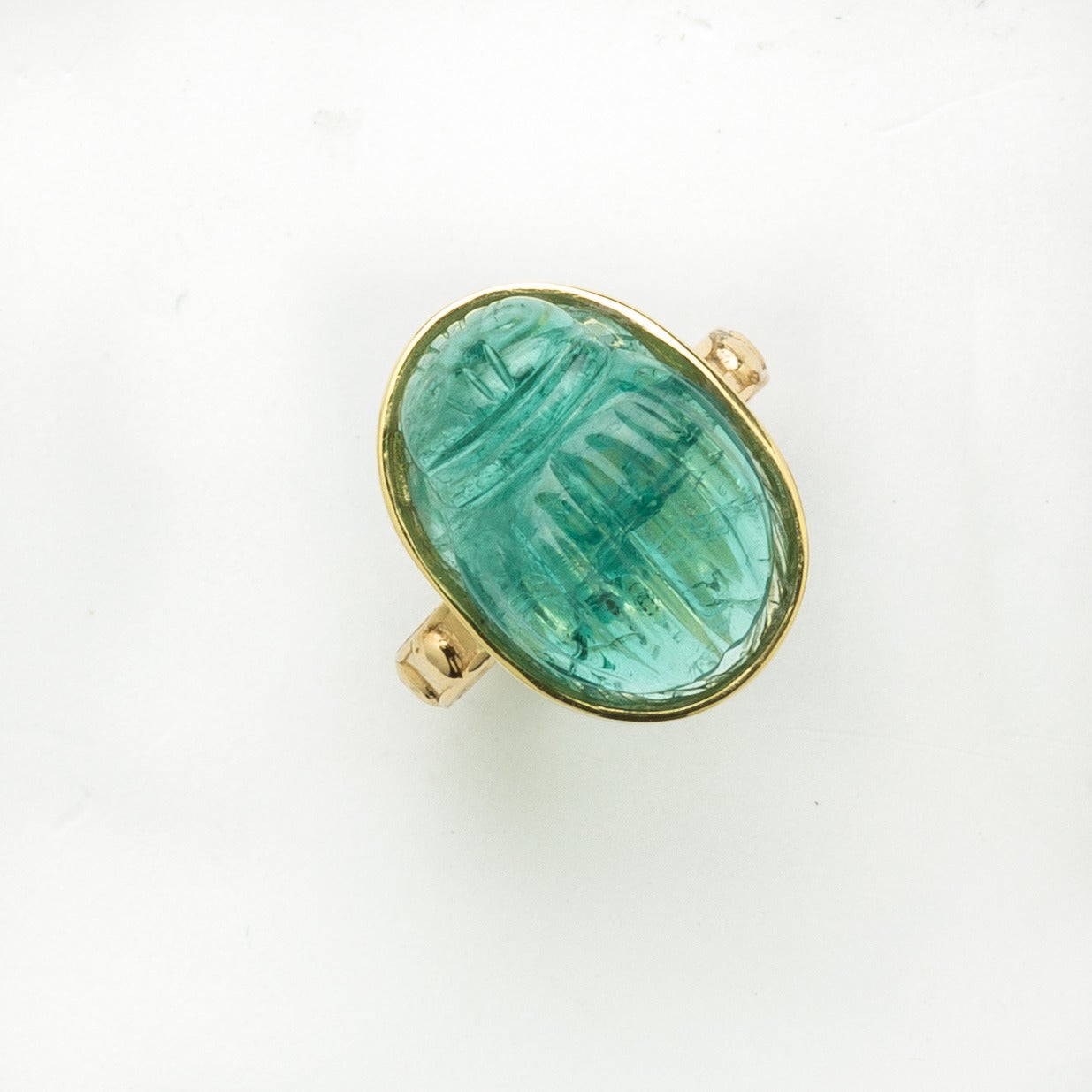 This blue/green tourmaline hand carved scarab is luminescent. Set in an 18 karat polished yellow gold shank (prayer ring style). Size 7.5 Can be sized to fit. Created by Master Idar-Oberstein artist.