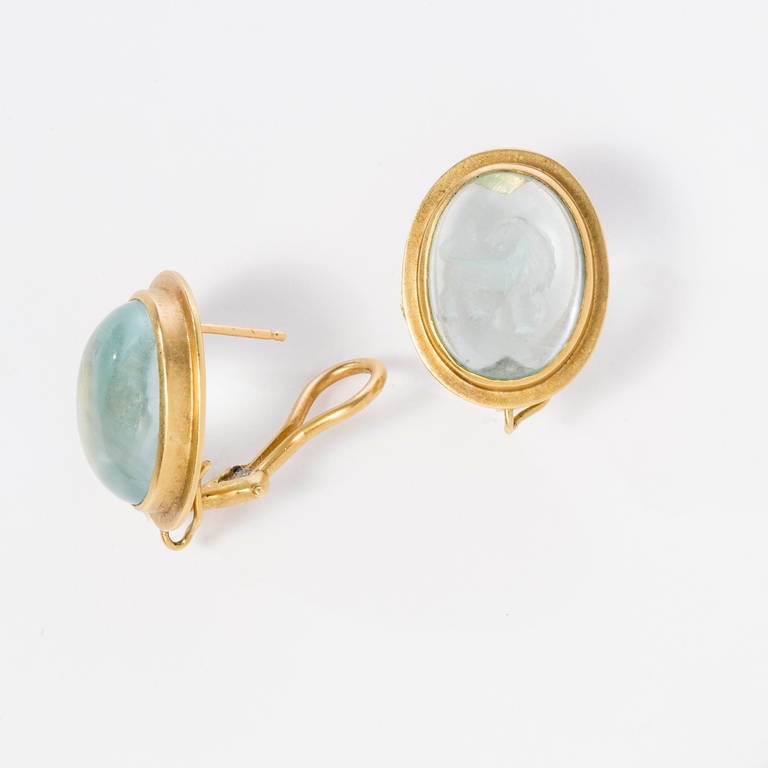 Beautiful hand carved aquamarine regal lion (by Master Idar-Oberstein carver)
intaglio cabochon earrings set in 18 karat polished yellow gold frame with gold omega clip backs for pierced ears. Gold wire for adding detachable drops. Stone size