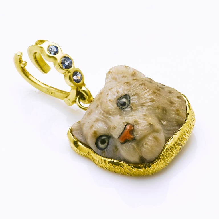 Here is a sighting of a rare and elusive snow leopard! Face carved  in such realistic detail from petrifed palm (by Master Idar-Oberstein carver) with carnelian nose and painted crystal eyes. This lovely piece is framed in 18 karat yellow gold with