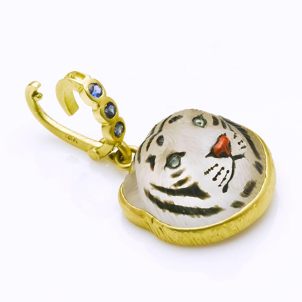 Beautifully hand painted & carved griasol ( white quartz crystal) tiger's head pendant with peridot eyes, coral nose.  Created by Master Idar-Oberstein carver.  Set in 18 karat brushed gold with  blue sapphire (.30carats) enhancer included. 
