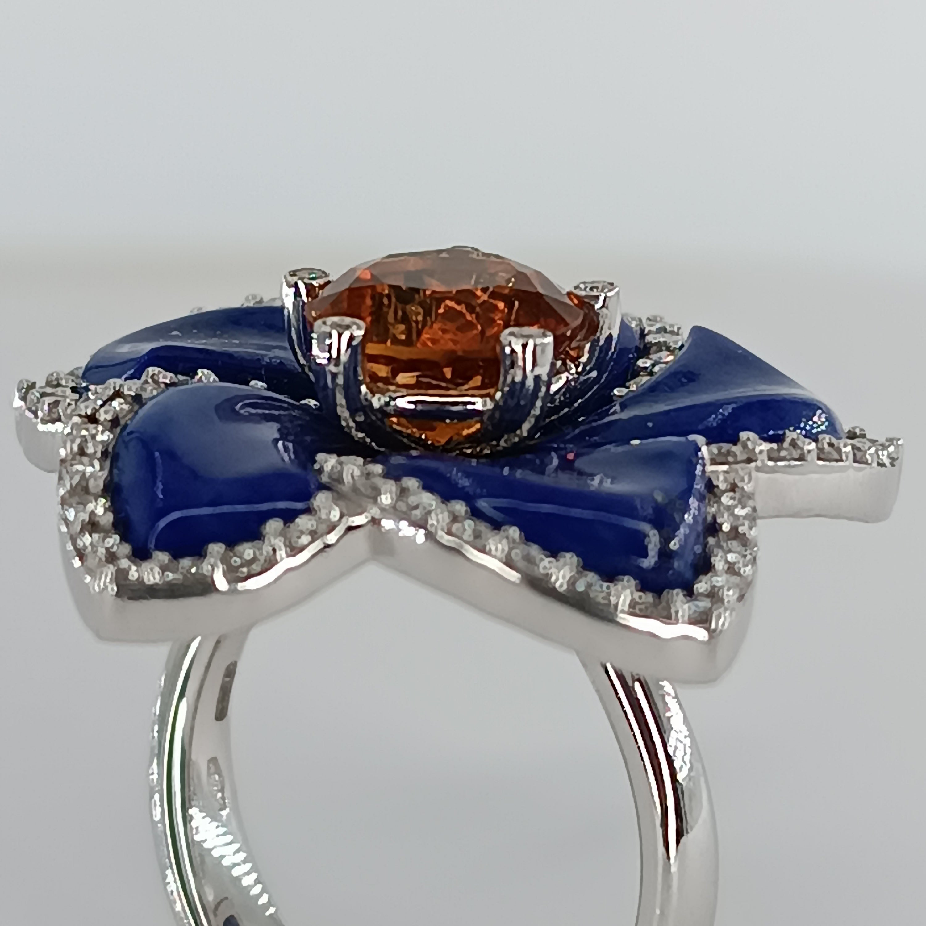 18 carat withe gold ring with lapis petals  and round faceted citrine stone  Carat. 1,96 surrounded by brilliant cut diamonds with a Total weight of Carat 0.78, color G, clarity VS 1. total gross weight gr. 12,43 ring size 54
any item of our jewelry