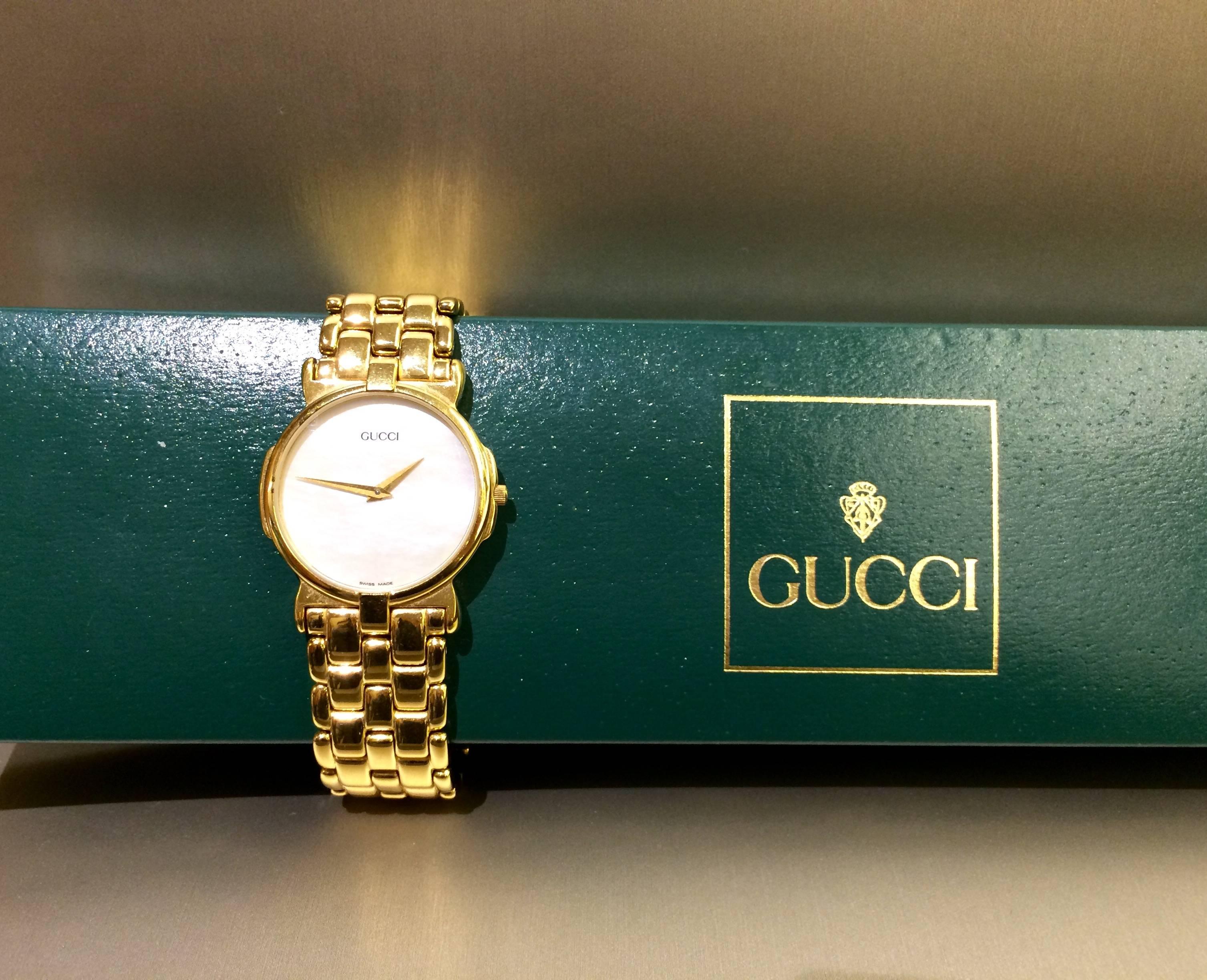 Gucci stainless steel watch plated yellow tone, mother of pearl dial, quartz movement. Comes with classic green Gucci box. Circa 1980's