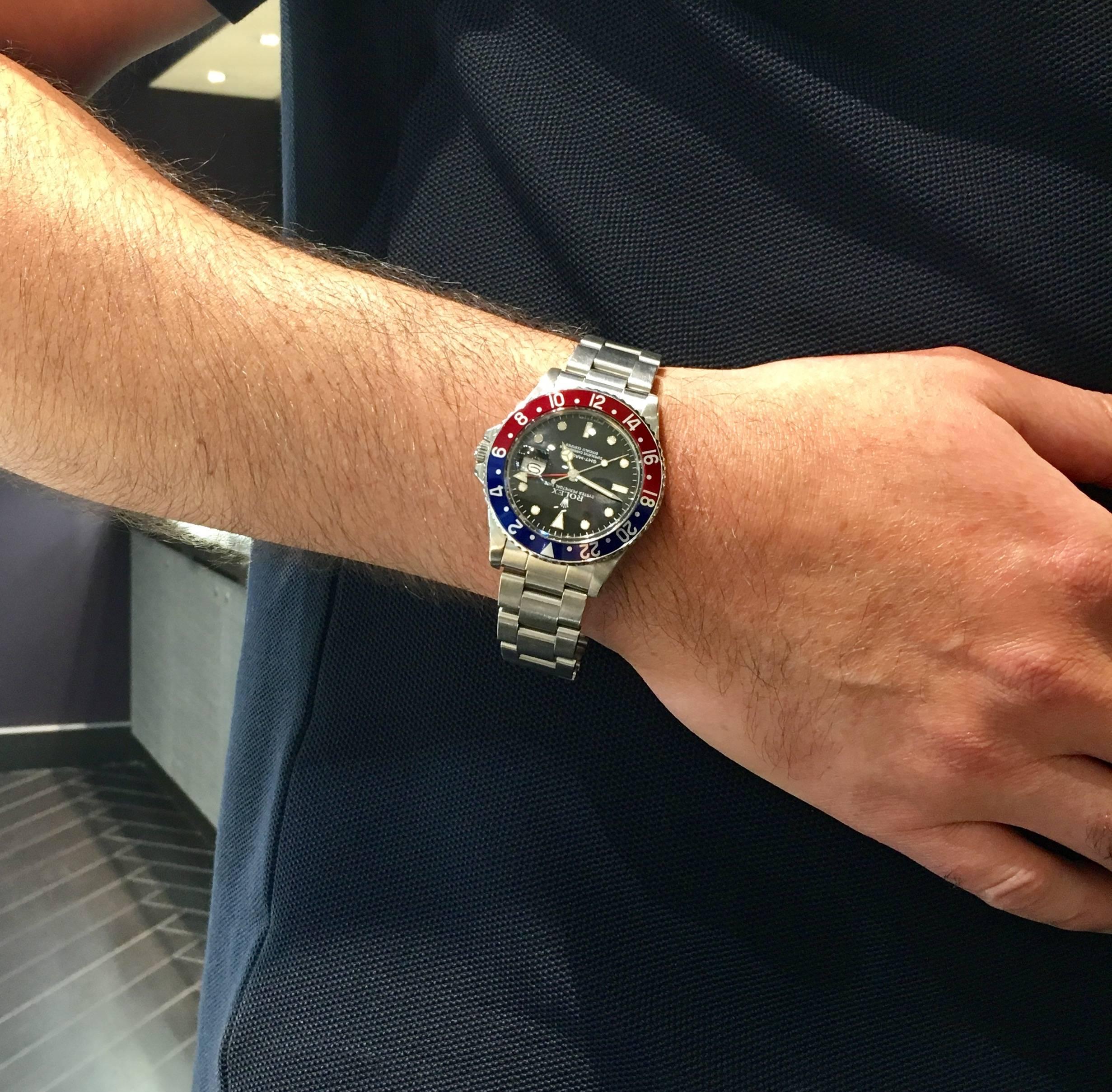 One pre-owned Rolex oyster perpetual GMT-Master in stainless steel. This classic Rolex features a black dial, a blue and red aluminum  "Pepsi bezel" insert, 20mm stainless steel oyster bracelet with 15 links including end piece black. 