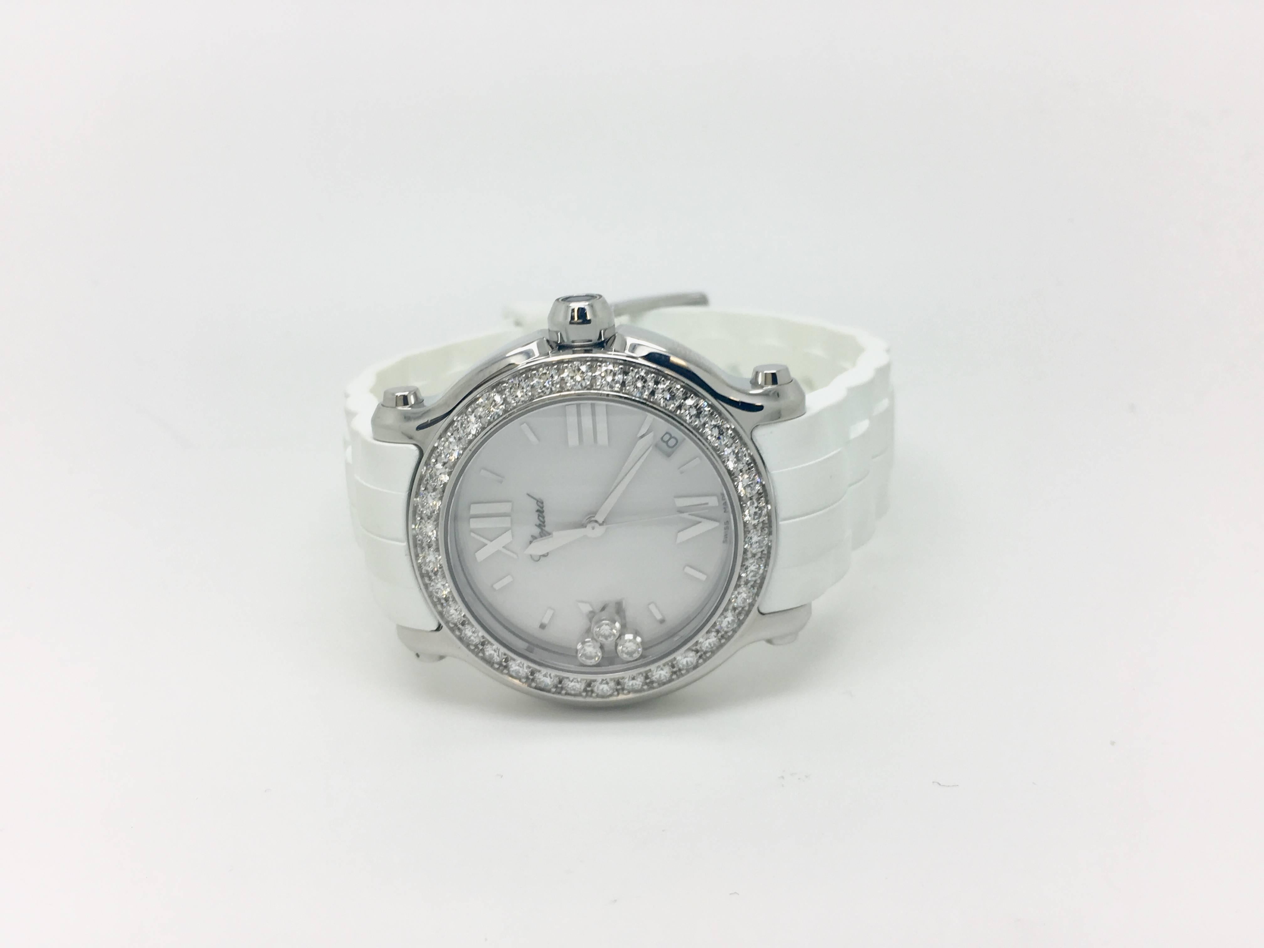 Chopard Happy Sport 36mm wristwatch with diamond bezel and quartz movement. It has a stainless steel 12mm thick case and beautiful diamond bezel with moving diamonds on face of timepiece. This item is pre-owned and has a rubber white strap that
