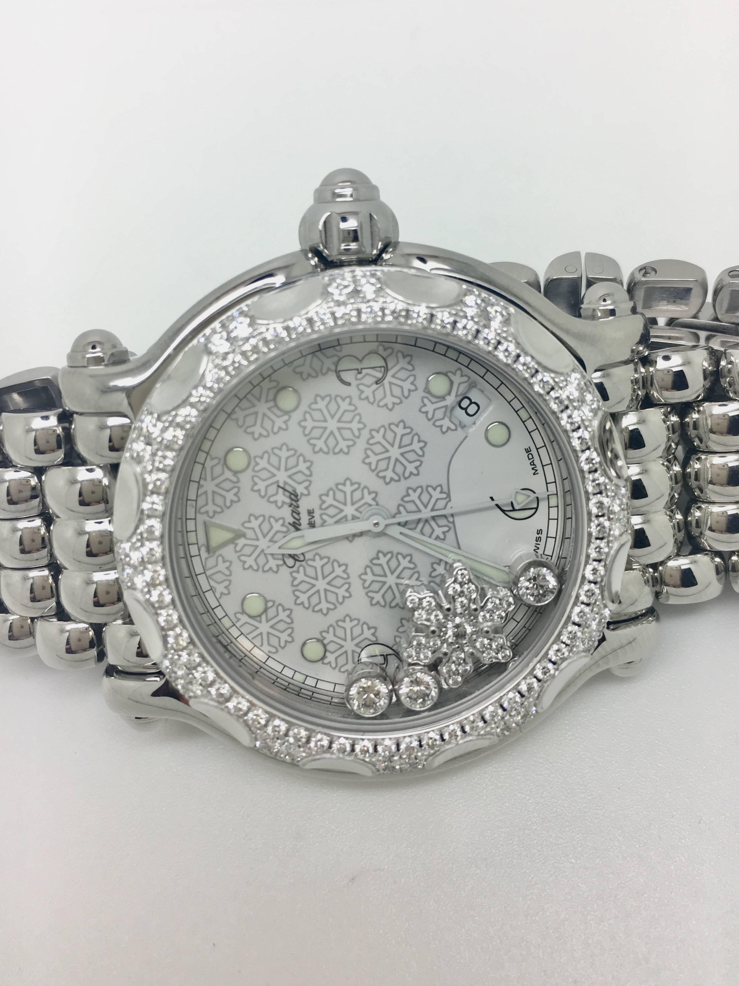This Chopard 'Happy Sport Snowflake' watch has a stainless steel case and bracelet. White dial with luminous hands and luminous dots hour markers. Luminescent hands and dial markers. Date displays between the 4 and 5 o'clock position. This timepiece