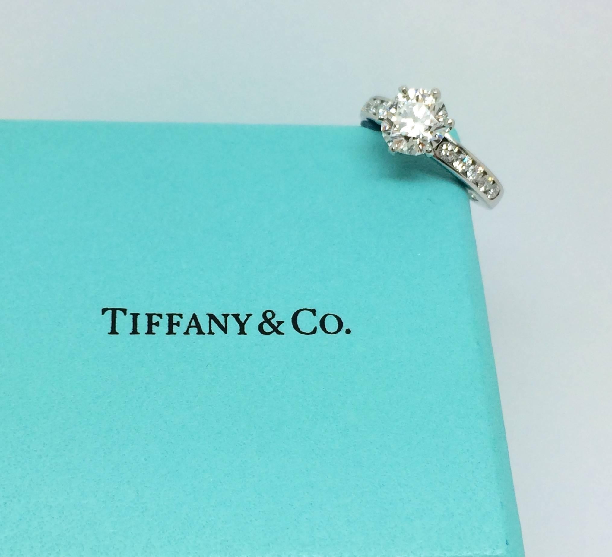 This stunning and timelessly classic Tiffany & Co. diamond engagement ring features a center round brilliant cut diamond 1.57 Carat / VS1 / H / Excellent Cut. The diamonds are set in a platinum ring mount with shoulder diamonds  0.35 T.W  VS1 / GH/
