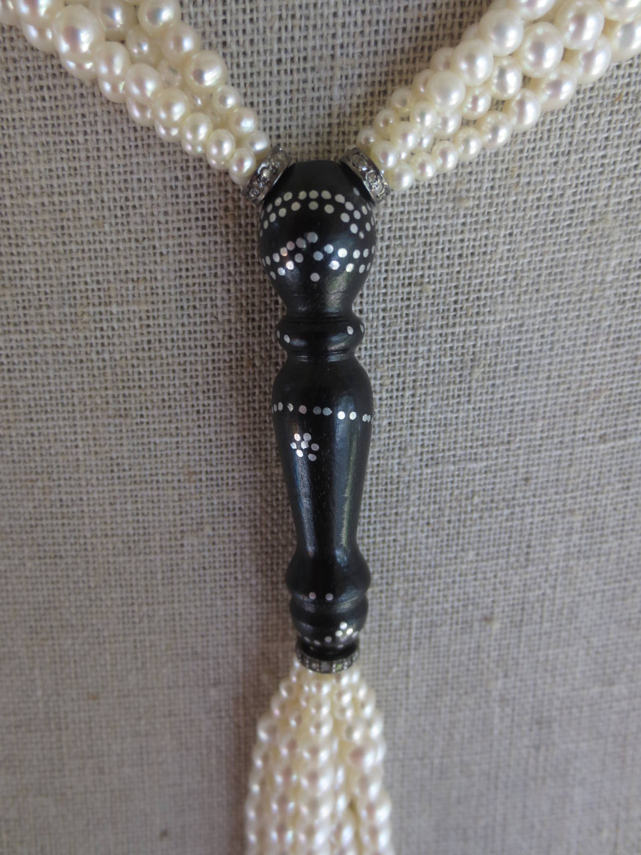 This elegant sautoir features slightly graduated pearl clusters between luxurious antique wood beads with silver nail inlay design. Faceted white gold beads and diamond encrusted sterling silver rondelles accent each cluster. Tassel features three