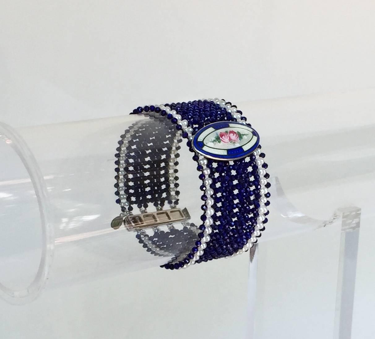 The beautiful and delicate enamel brooch is redesigned as the centerpiece of this elegant band bracelet. Tiny 1.5 mm pearls are delicately hand-woven with 1-2 mm lapis lazuli faceted beads creating a design and artistry reminiscent of a bygone era.