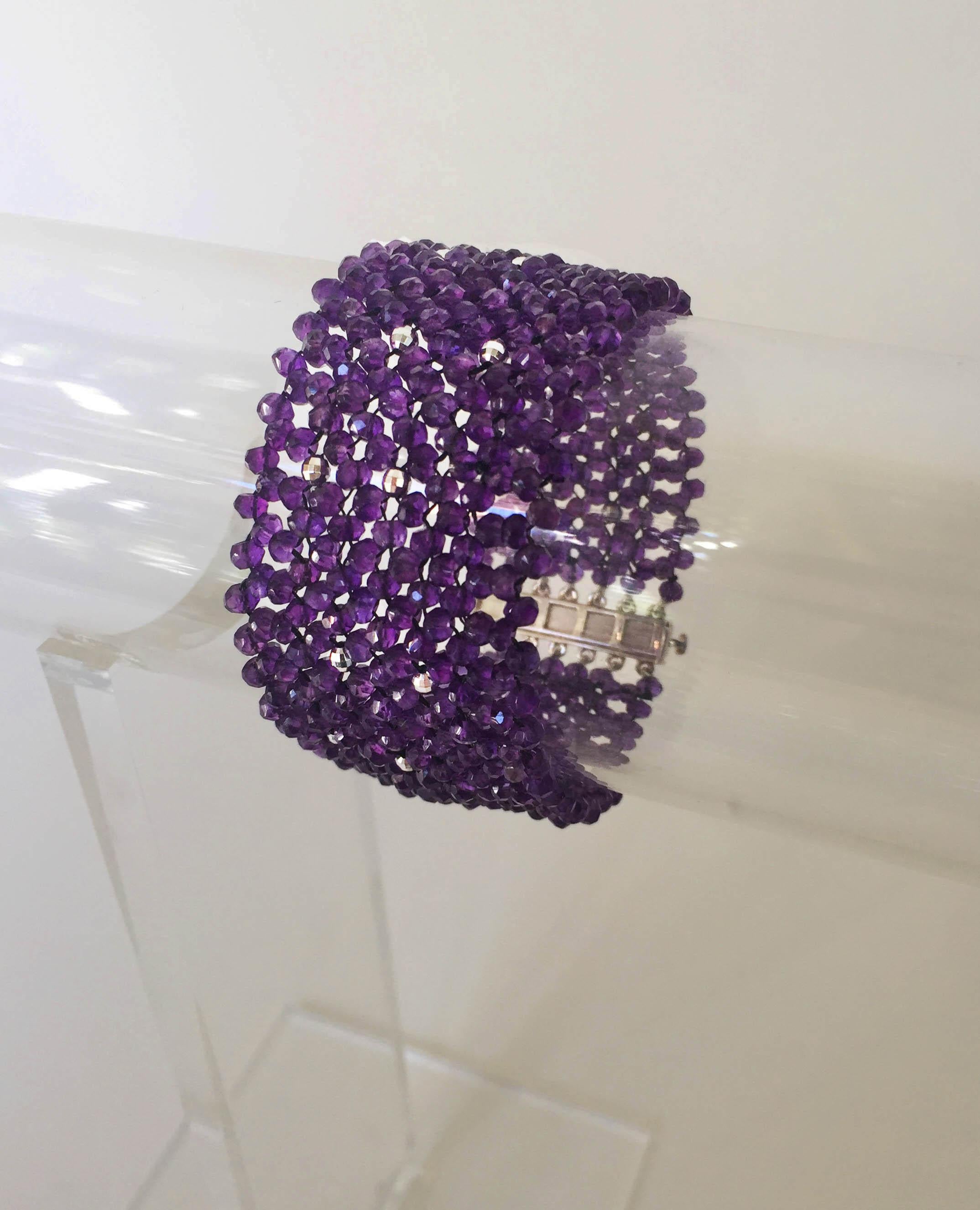 The woven faceted amethyst cuff bracelet with sterling silver clasp and beads is a beautiful shade of deep purple. At 1.25 inches wide and 7.15 inches long this bracelet gracefully drapes the wrist. The rhodium plated silver beads twinkle throughout