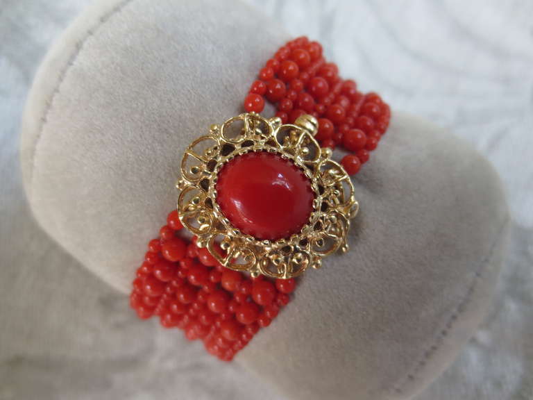 Beautiful and delicate 14K gold clasp is set with a coral cabochon and complemented by red coral beads. Bracelet is intricately woven with 2 and 3 mm coral beads that perfectly match the cabochon found on the clasp. Bracelet measures in 17cm length,