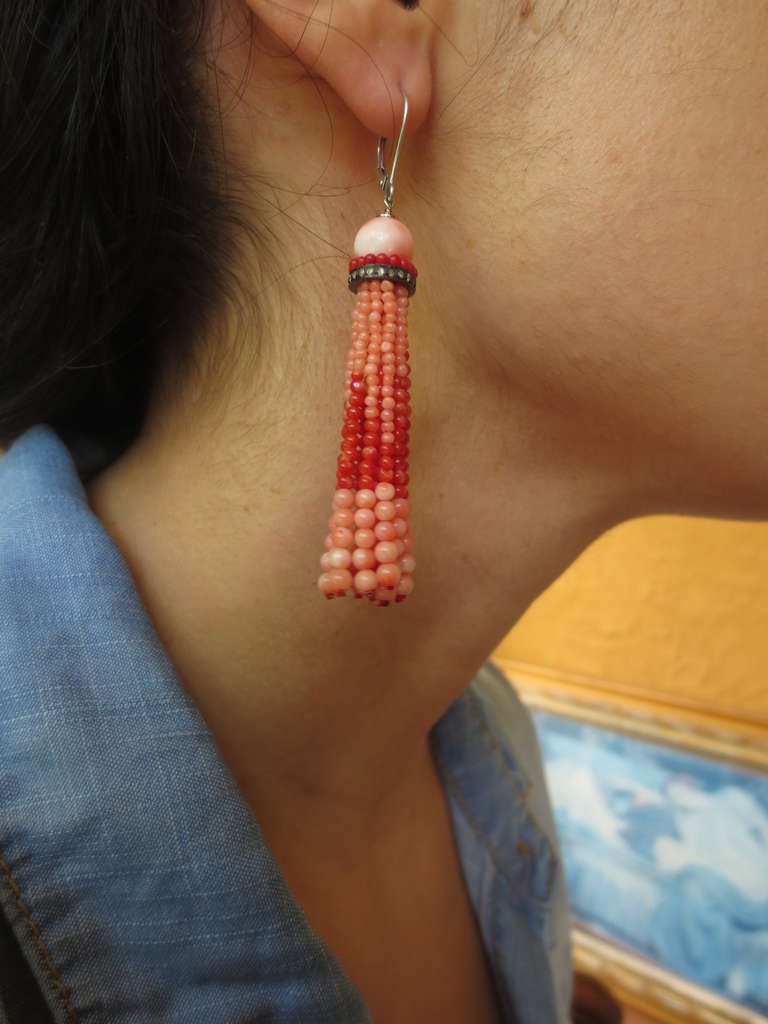 These elegant earrings  are made of tiny hand selected coral and onyx beads. The strands are made of 1 to 3mm two tone coral beads to create a light and ethereal effect. The strands hang from a larger carved coral bead accented by tiny red and black